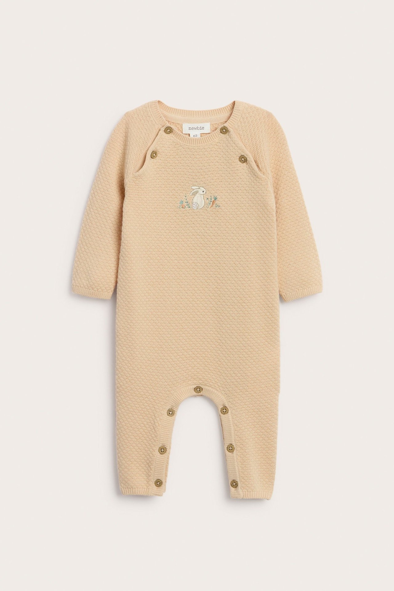 Front view of a light orange textured knit cotton baby jumpsuit with an embroidered rabbit and snap buttons.