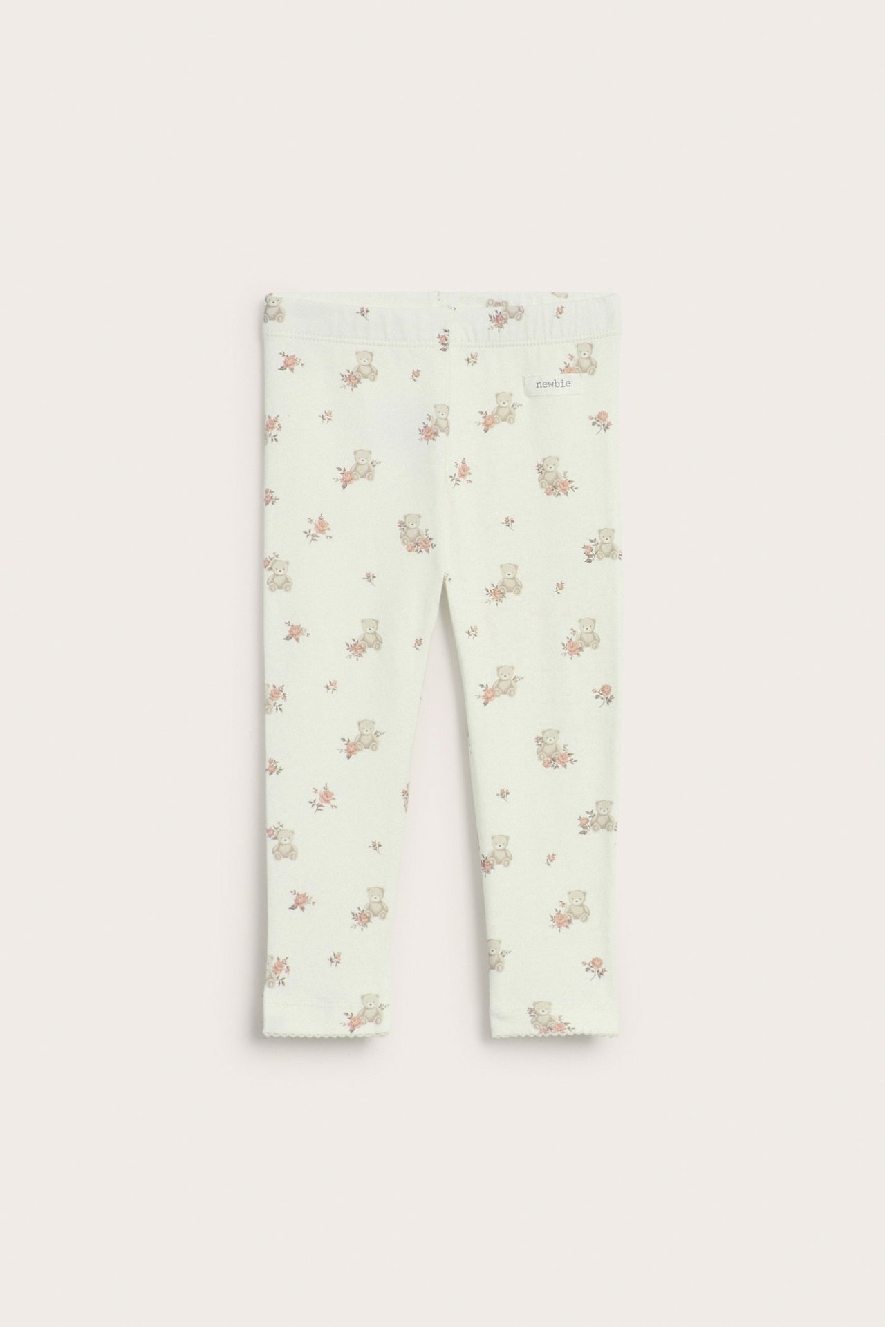 Vorderansicht von cremefarbenen Baby-Leggings mit Gummizug und niedlichem Bären-Blumen-Print, Picot-Borte.