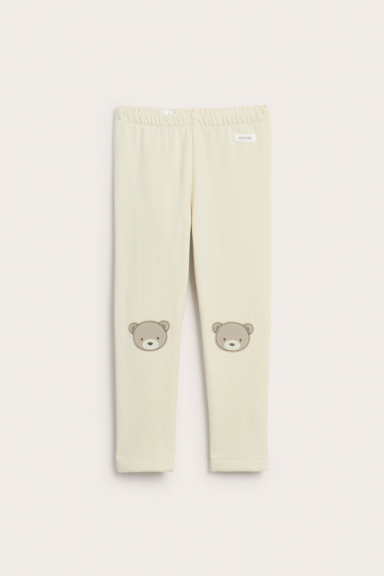 Vorderansicht: Hellbeige Baby-Leggings mit Gummizugbund und Bärenapplikationen an den Knien.