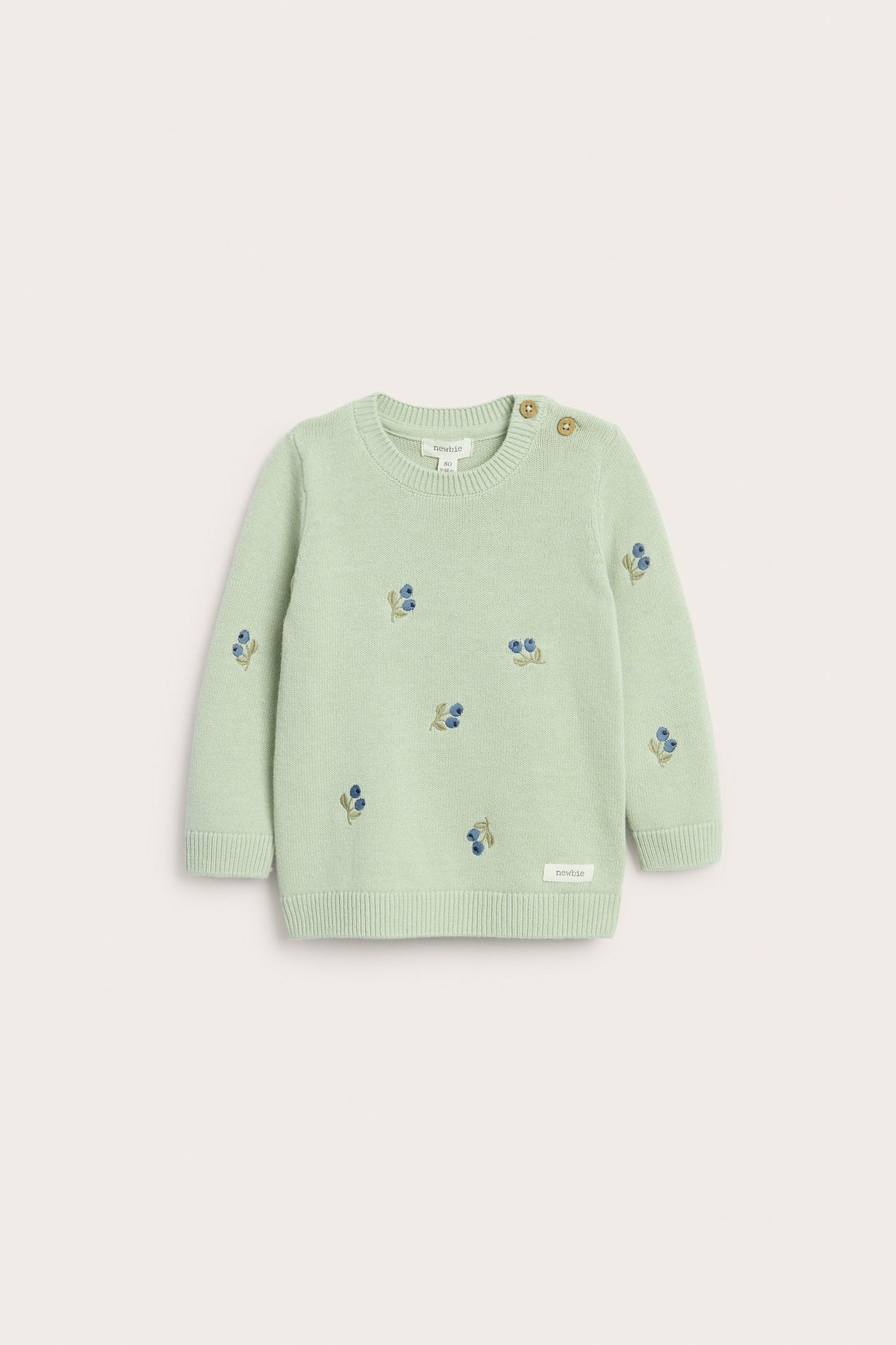 Front view of a light green baby jacquard-knitted sweater with blue berry embroidery and shoulder buttons.