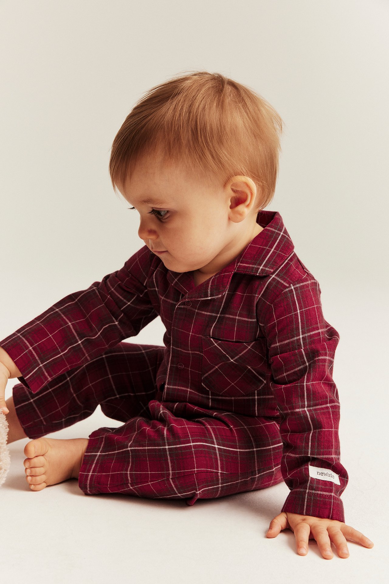 Red plaid flannel pajamas for kid with front buttons, matches mother.