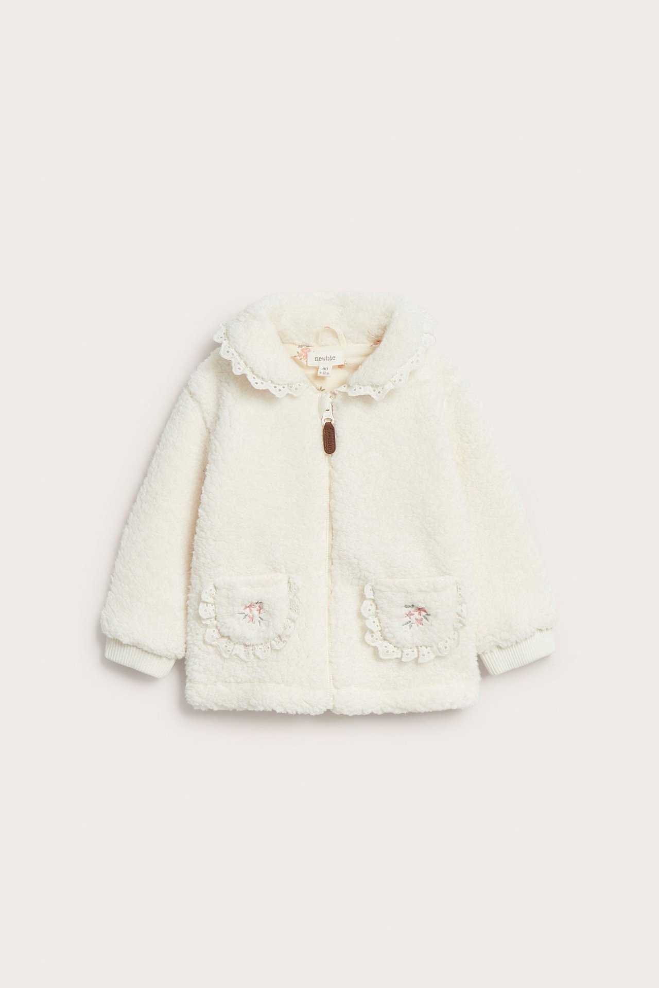 Vorderansicht cremeweißer Kinder-Fleecejacke mit Spitzenkragen, Reißverschluss, bestickten aufgesetzten Taschen.
