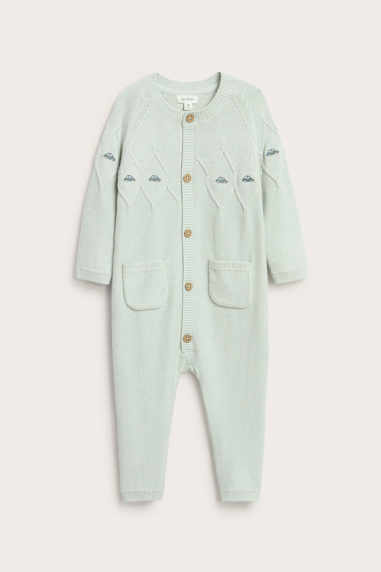 Hellblaue, strukturierte Jumpsuit für Kinder mit Stickerei, Knöpfen, Taschen und Rippbündchen.