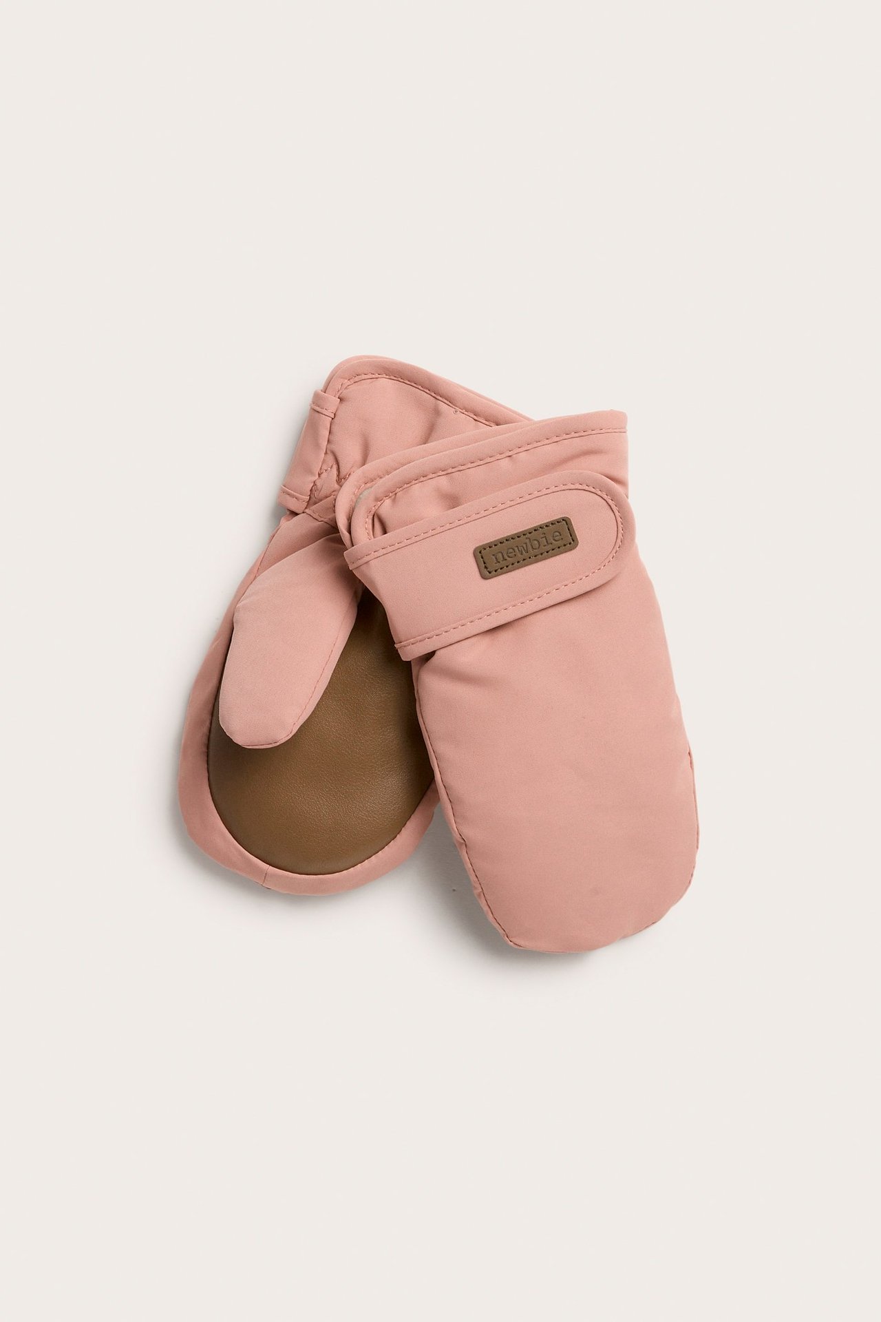 Draufsicht auf rosa gefütterte Fäustlinge mit braunen Handflächen und Klettverschluss an den Bündchen.