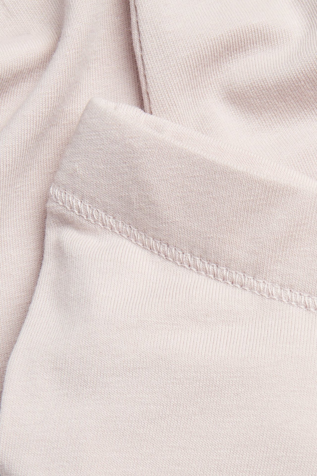 Nahaufnahme von helllila, einfarbigen, gerippten Leggings mit elastischem Bund.