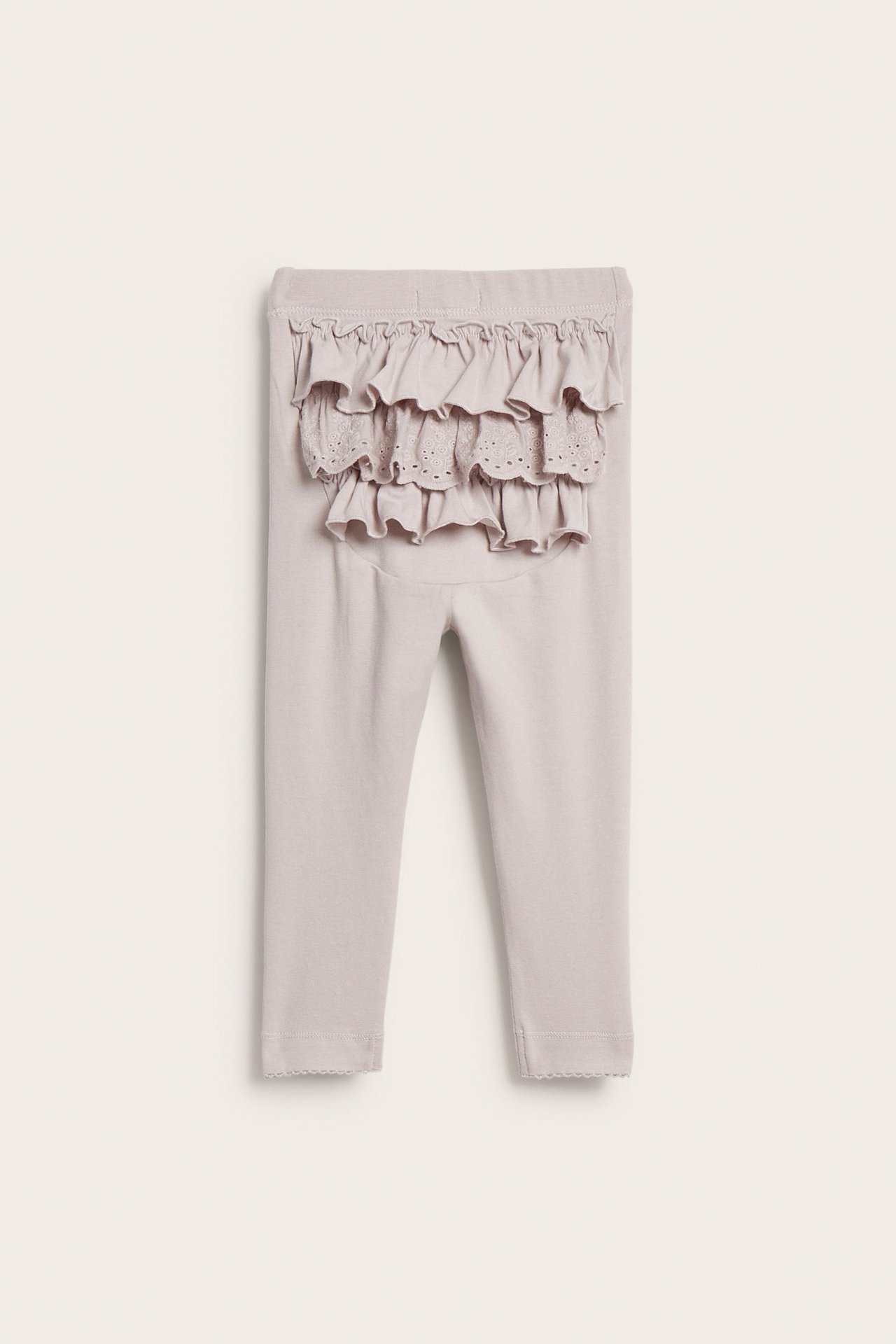 Rückenansicht einer hellfliederfarbenen Baby-Leggings mit elastischem Bund, Rüschen und Spitze am Po.