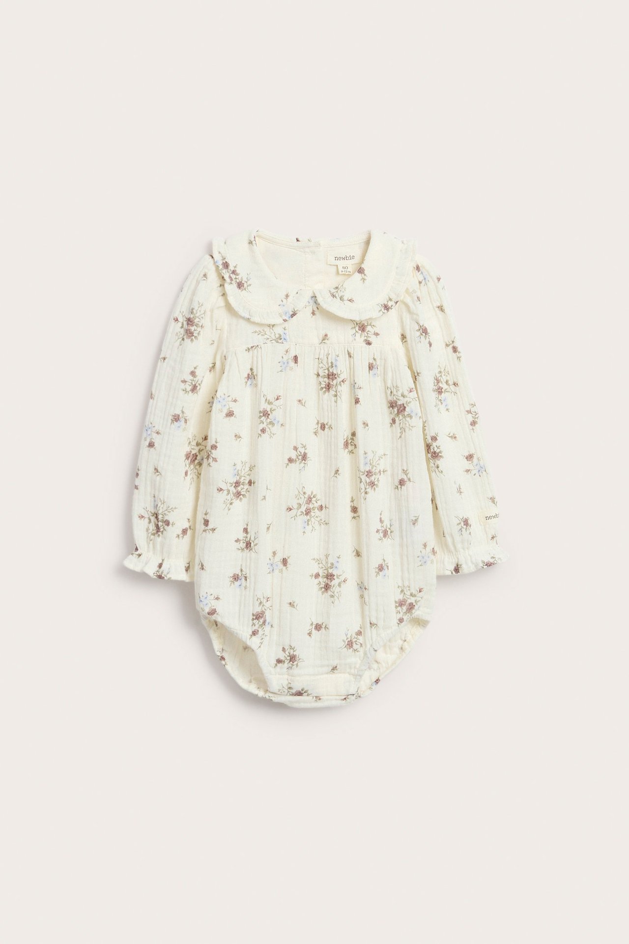 Front view: off-white cotton baby floral blousie bodysuit with frilled collar and long puff sleeves.