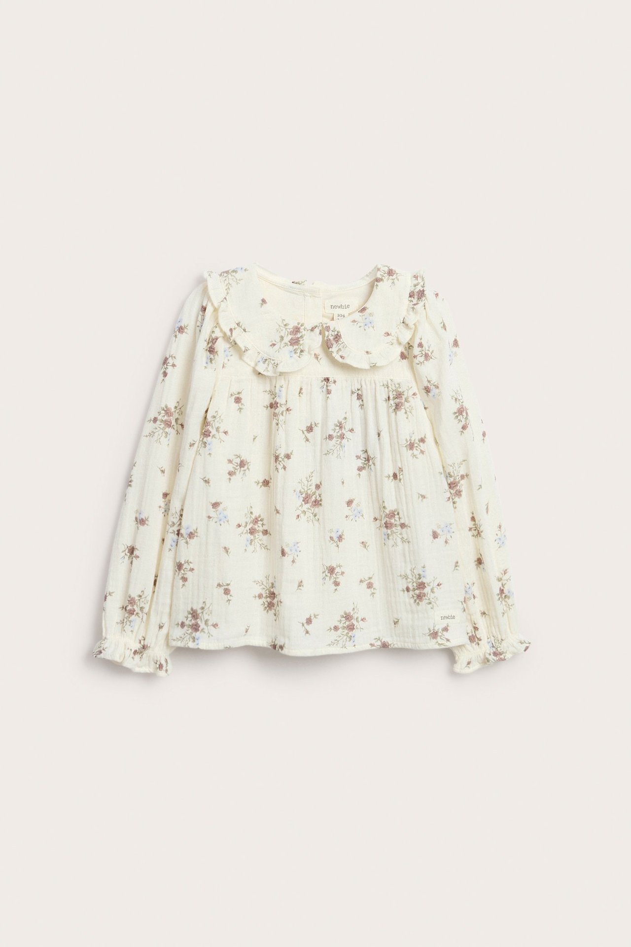 Front view: Offwhite floral cotton blouse with a ruffle collar and long puff sleeves.