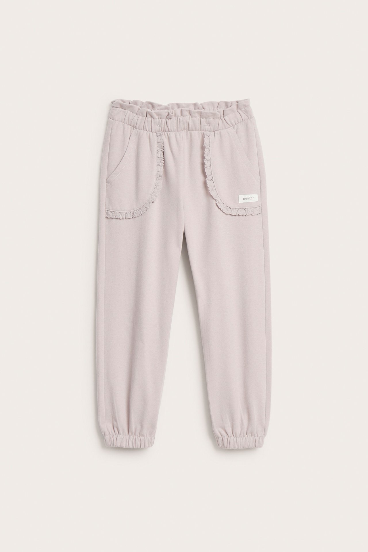 Front view of light purple kid's sweatpants with ruffled waist, ruffled pockets, and elastic ankles.