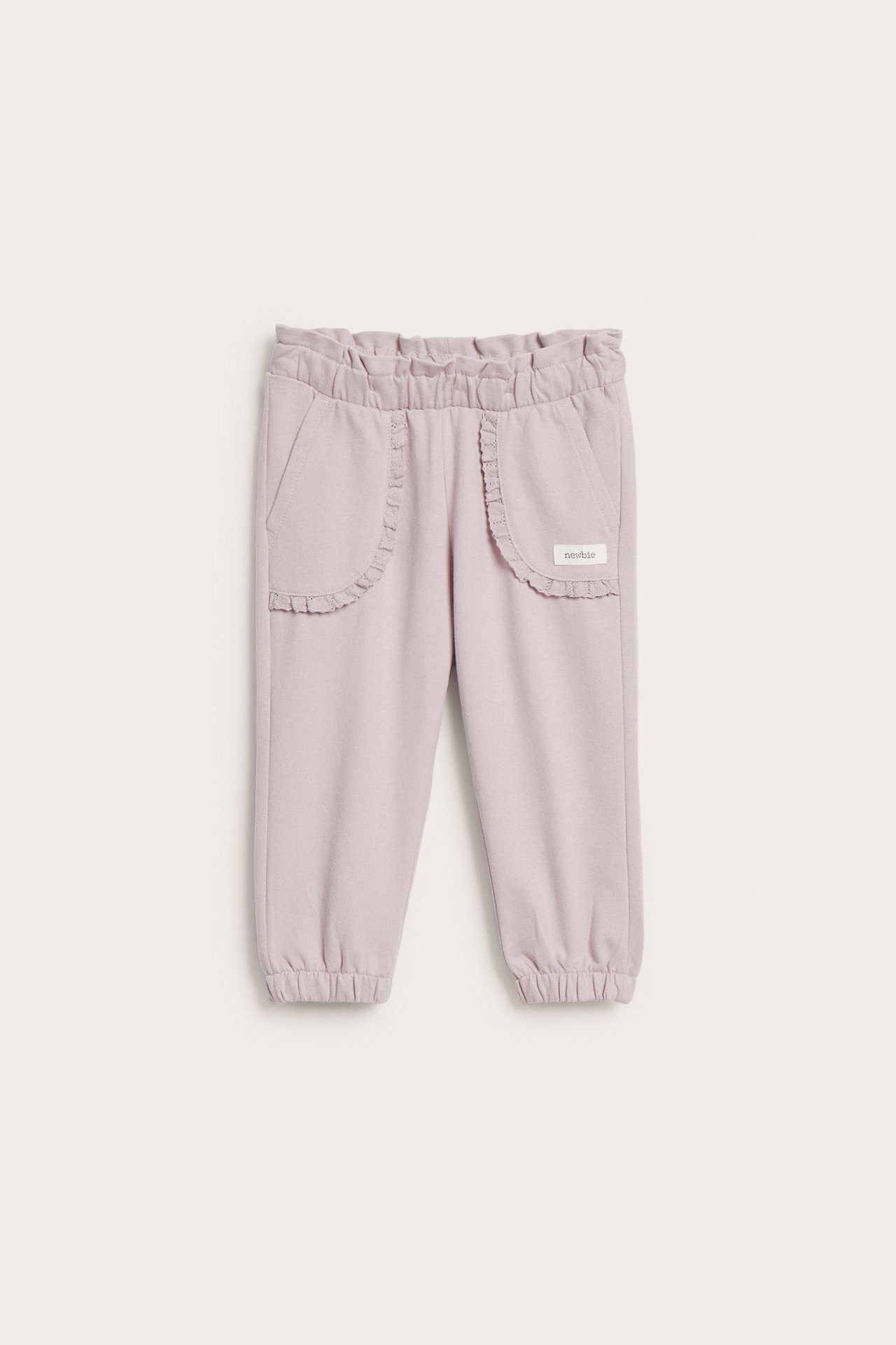 Front view of light purple kid jogger pants with ruffled pockets and elasticated waist.