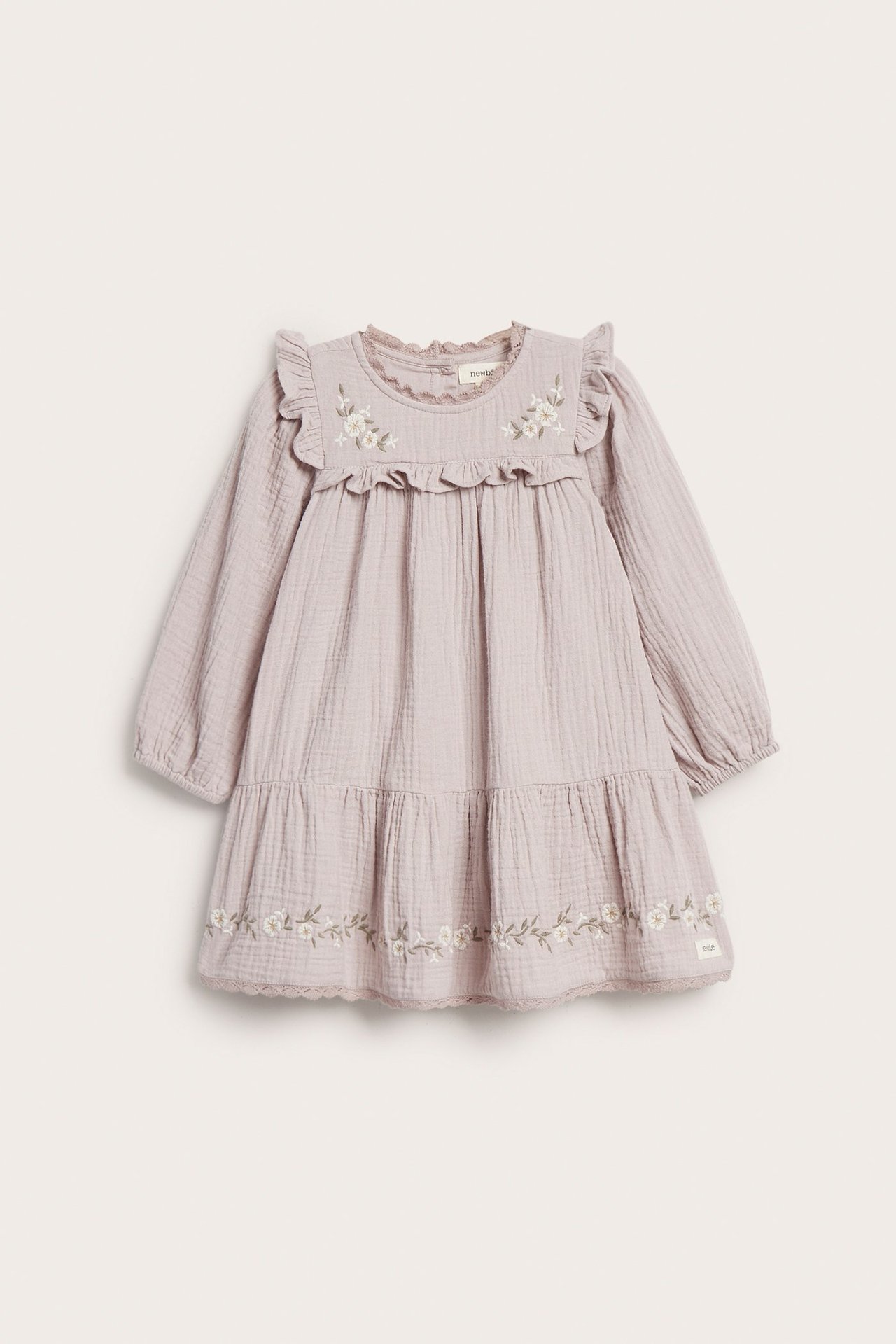 Front view of a textured lilac kid's dress with ruffled yoke, floral embroidery, lace, and puff sleeves.
