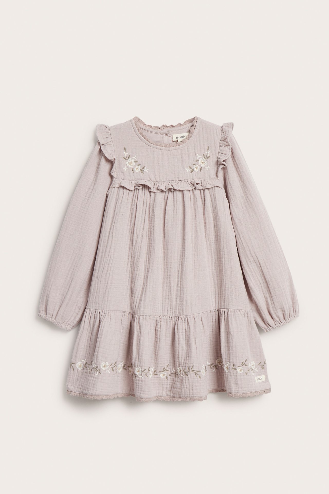 Front view of a kid's light lilac cotton dress with floral embroidery, ruffles, puff sleeves, and lace trim.