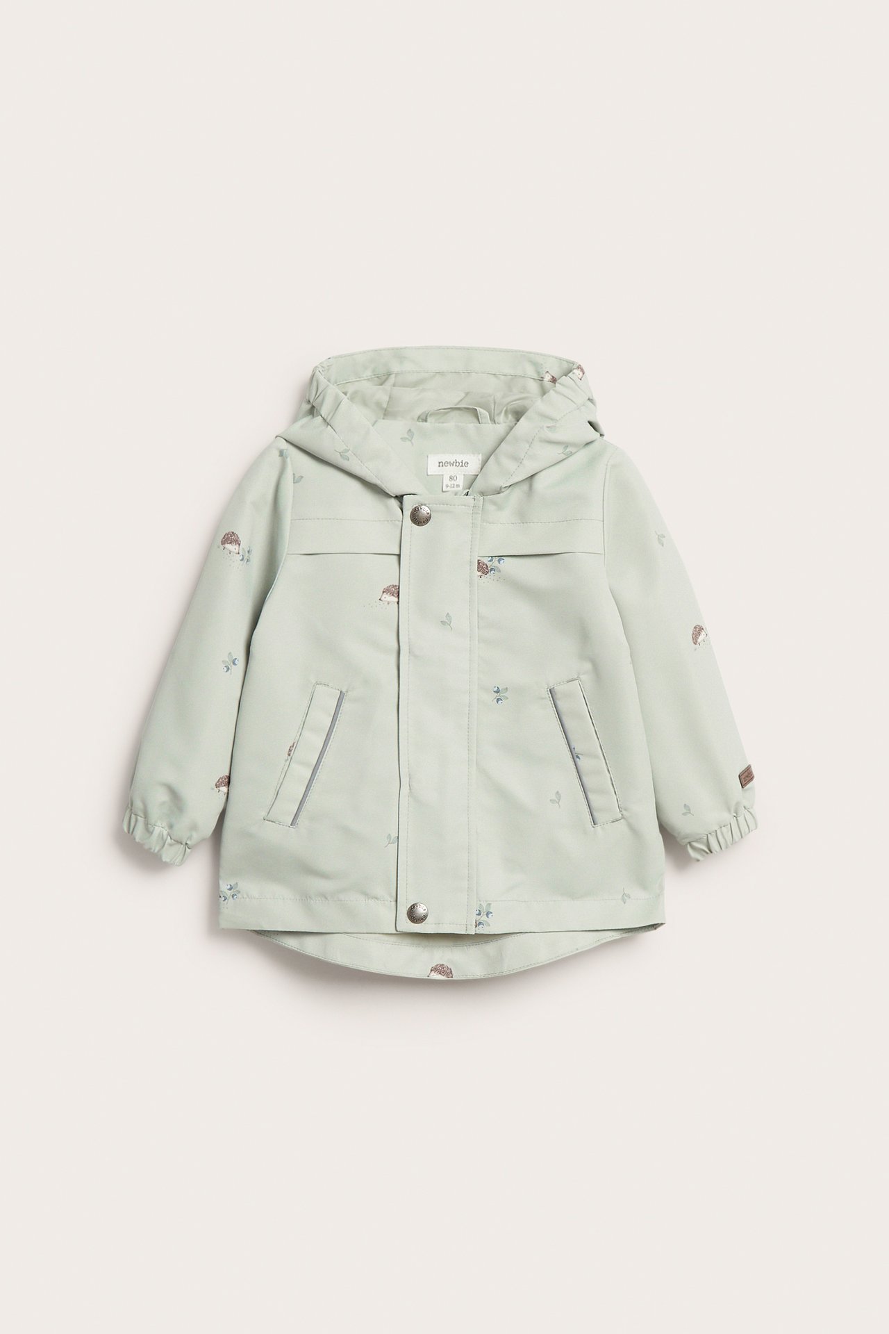 Front view of a kid's light green hooded jacket with hedgehog pattern, zip and snap button fastening.