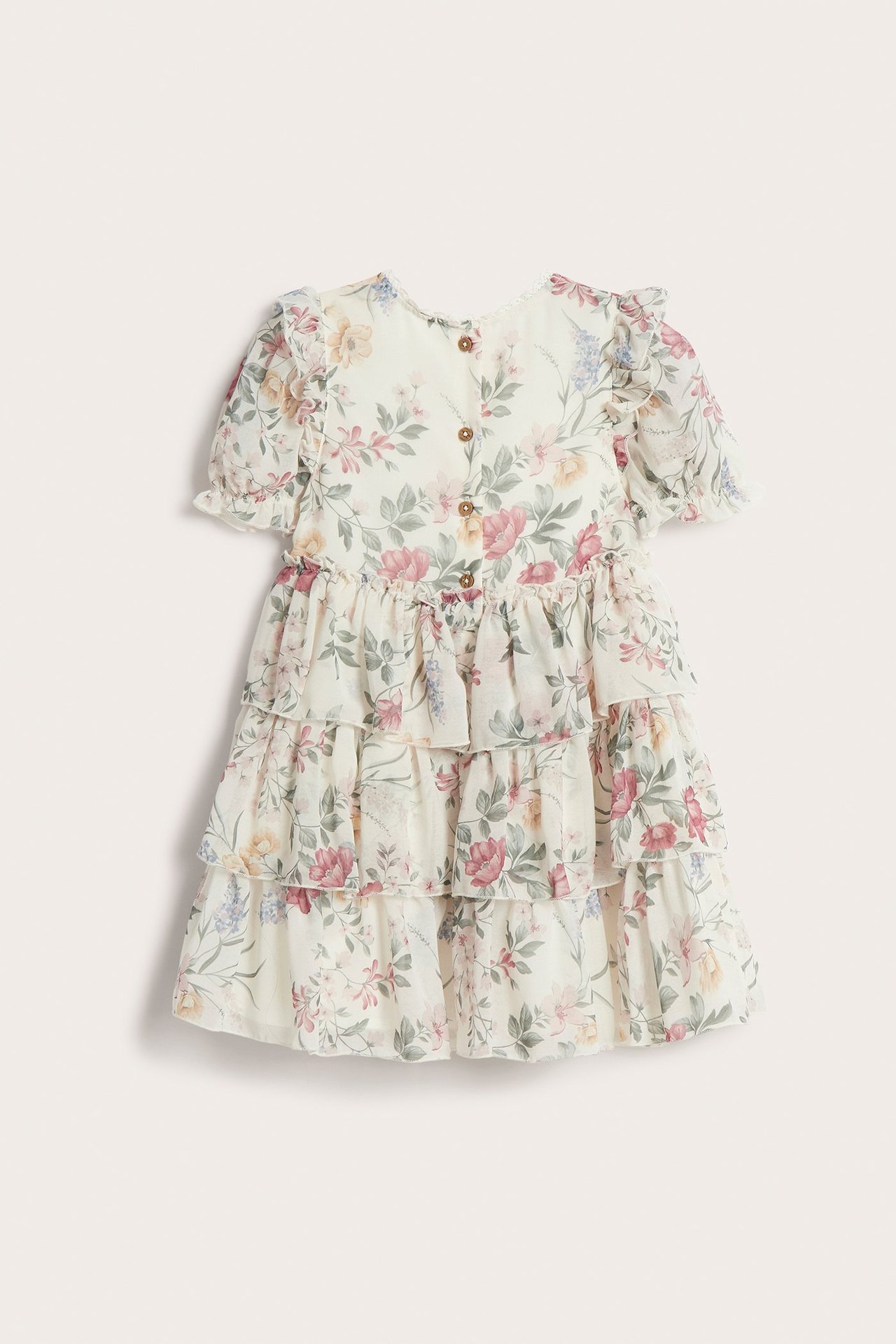 Rückenansicht eines offwhite geblümten Chiffonkleides für Kinder mit Rüschen, Puffärmeln und Knöpfen.