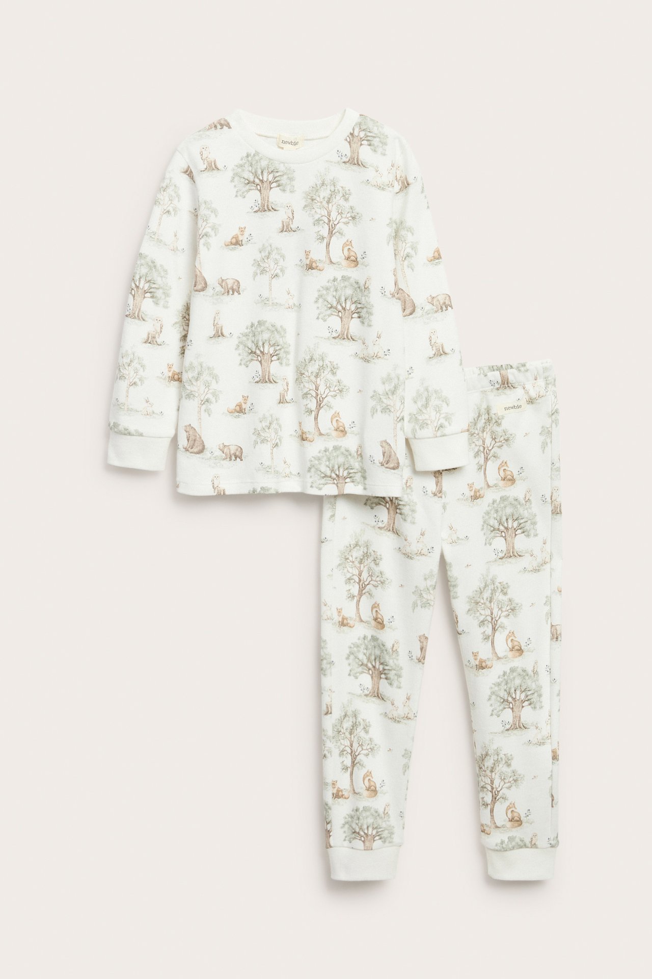 Front view: Kid's off-white cotton pajama set with a forest and animal print.