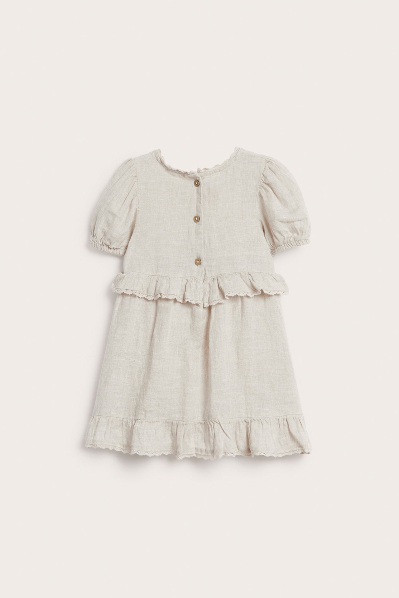 Vorderansicht: Beigefarbenes Leinenkleid für Kinder mit Puffärmeln, Rüschen, Spitzenbesatz und Knöpfen vorne.