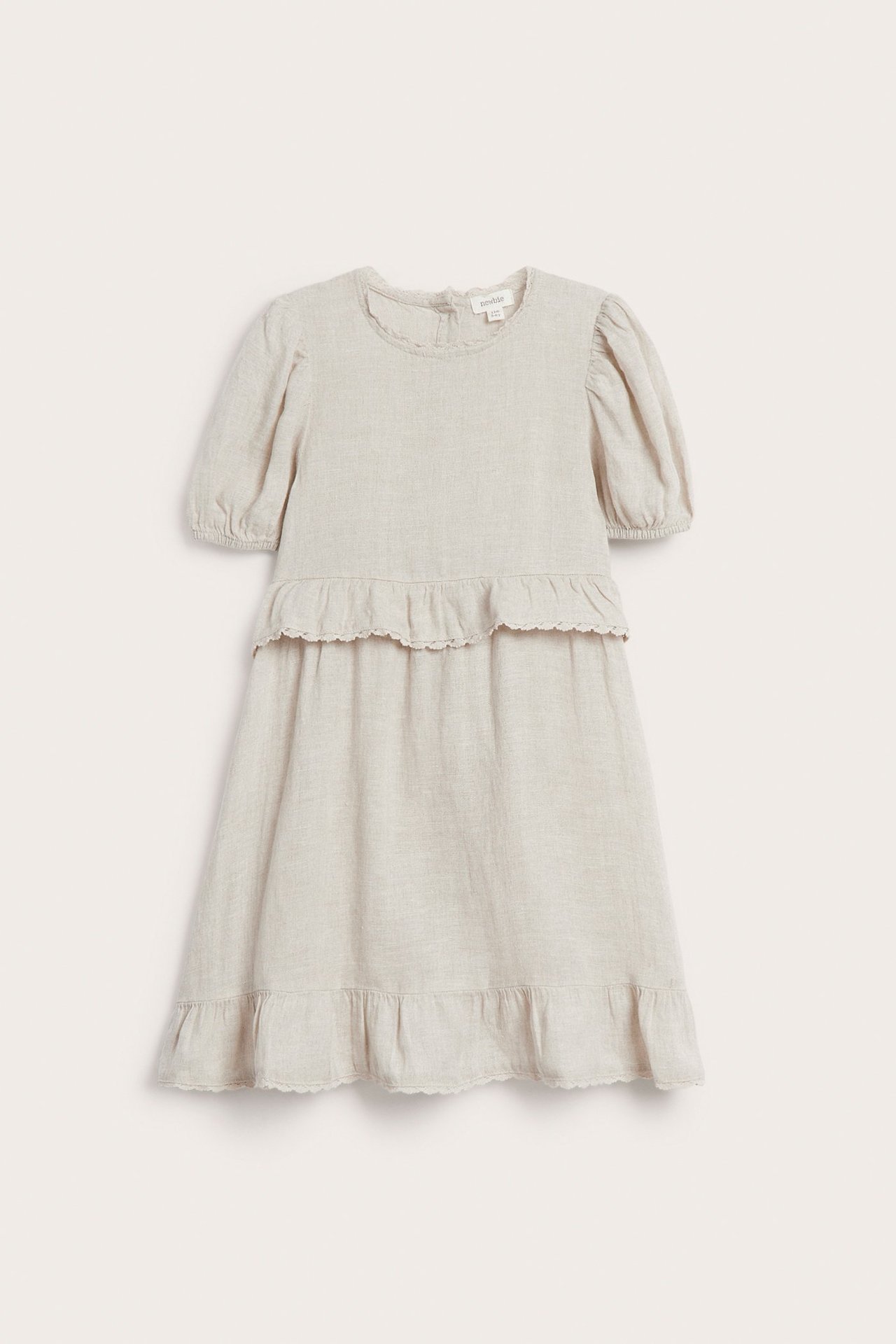 Front view of a light beige linen kid's dress with puff sleeves, chest ruffles, and a lace-edged hem.