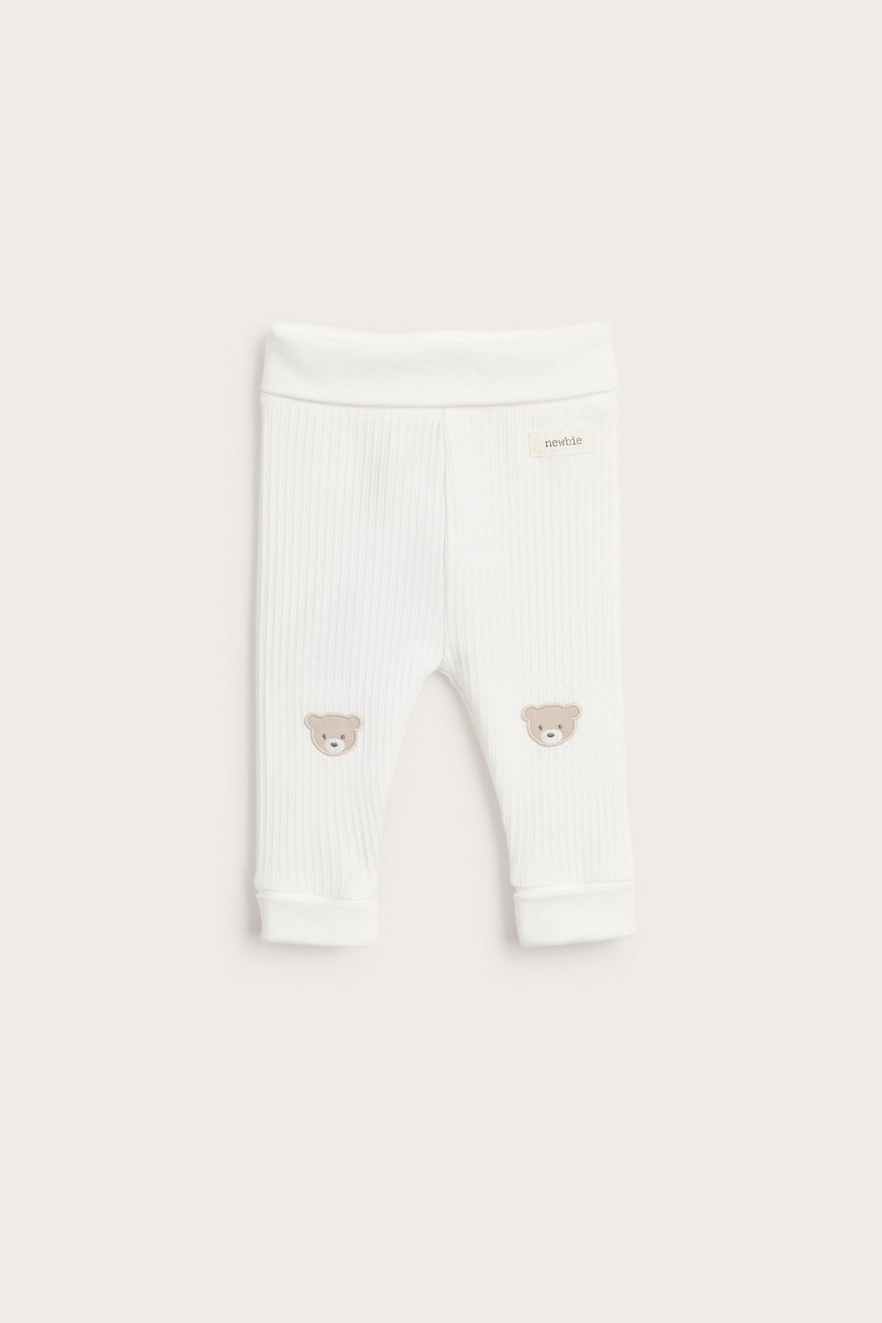 Vorderansicht von weißen gerippten Baby-Leggings mit beigen Teddybär-Applikationen an den Knien.