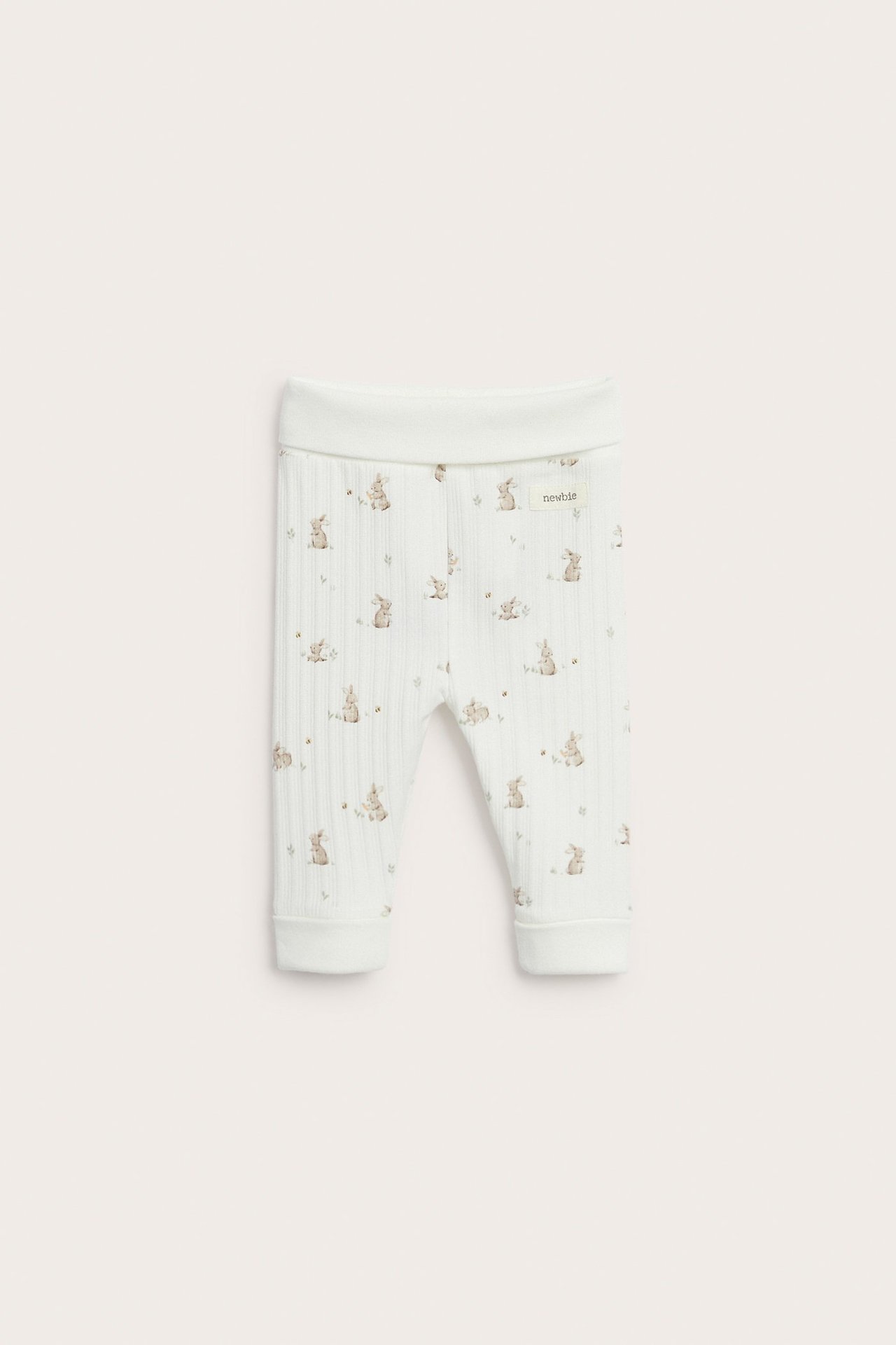Vorderansicht cremeweißer gerippter Baby-Leggings mit Kaninchendruck, umklappbarem Bund und Bündchen.