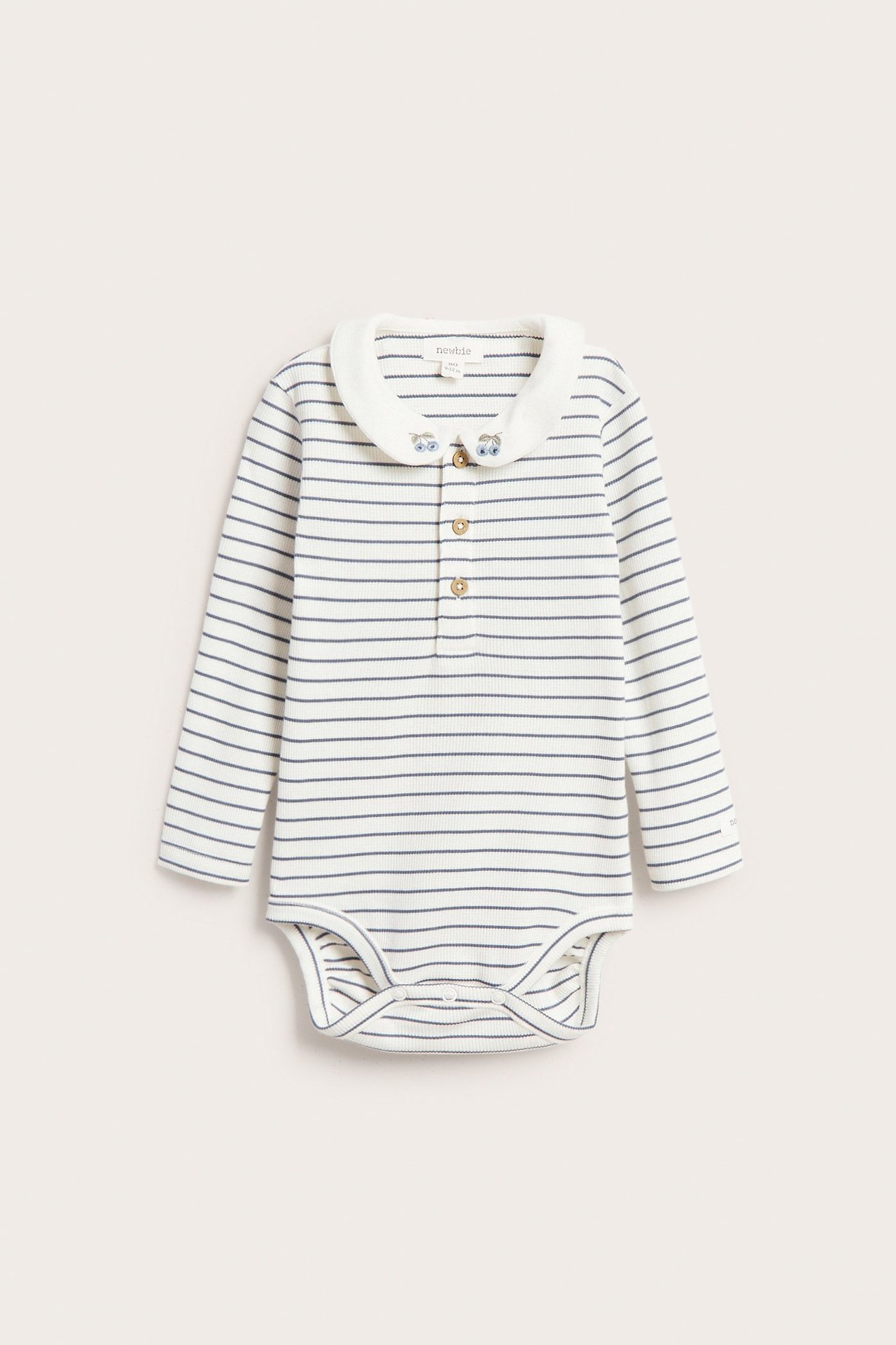 Vorderansicht eines offwhite gestreiften gerippten Babybodys mit langen Ärmeln, besticktem Kragen und Knopfleiste.