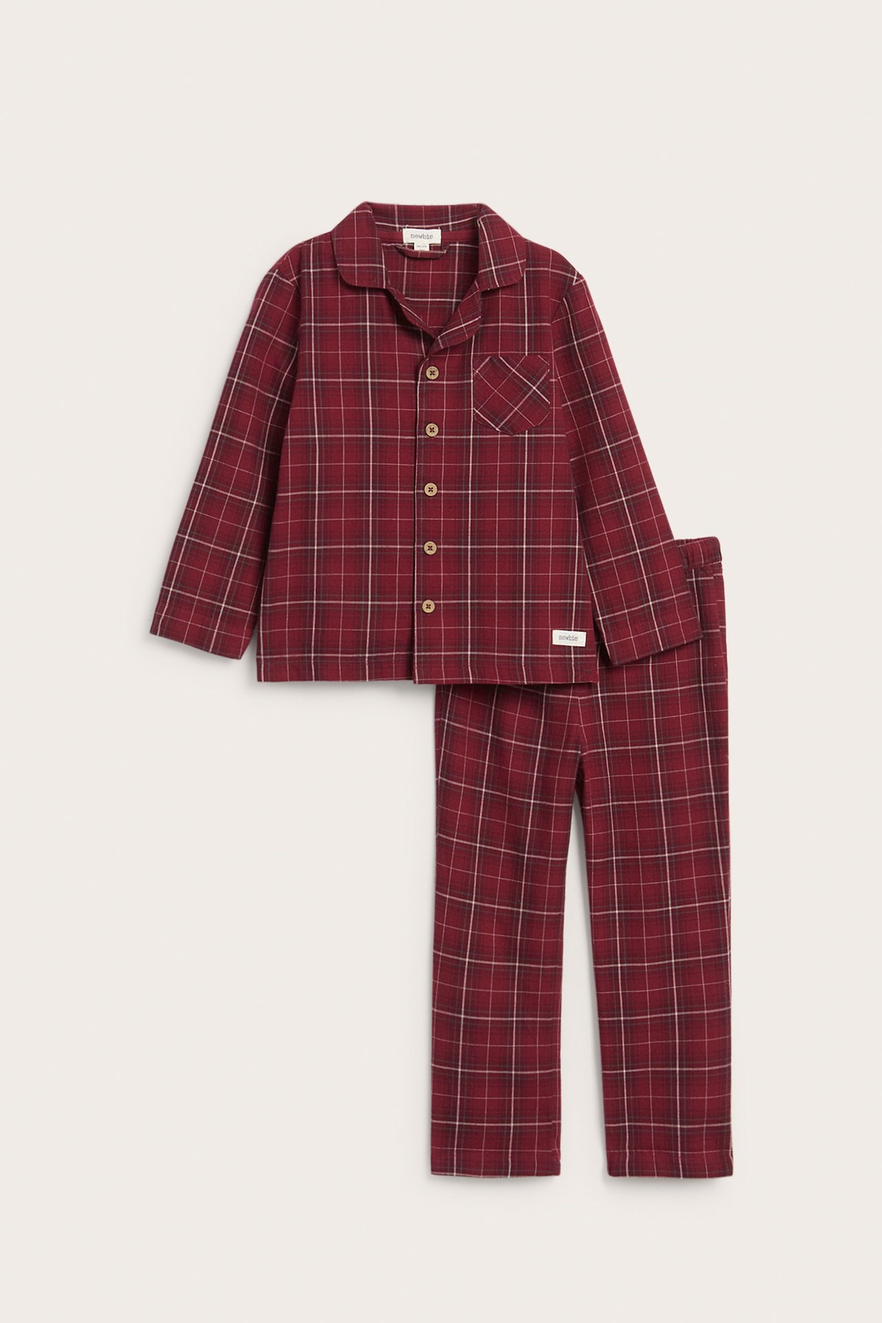 Vorderansicht eines rot karierten Flanell-Pyjamas mit Kragenhemd und langen Hosen.