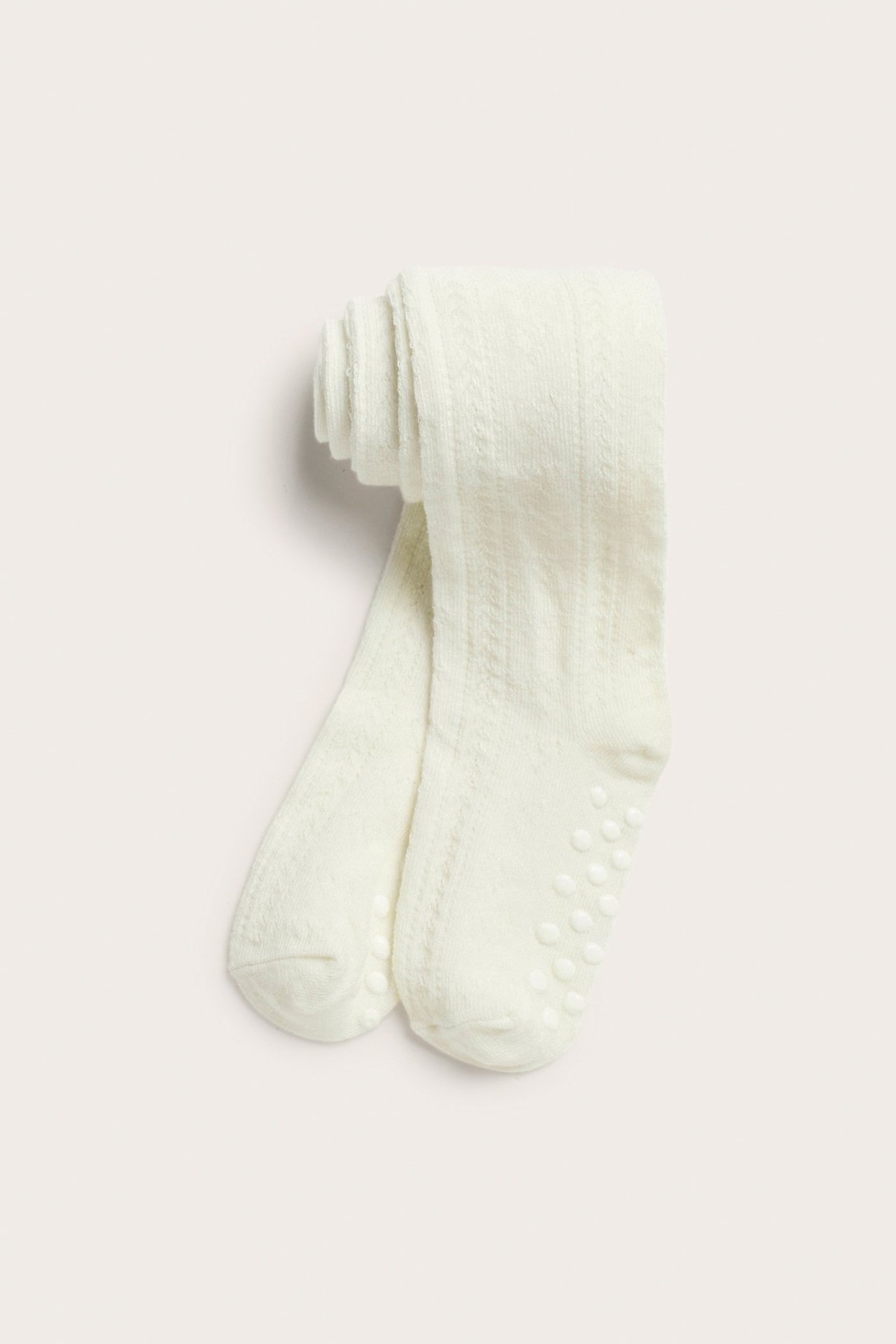 Draufsicht: Off-white gemusterte Babystrumpfhose mit Anti-Rutsch-Sohlen.