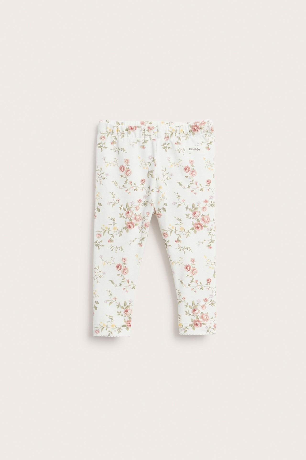 Front view of off-white baby leggings with a floral pattern and elastic waist.