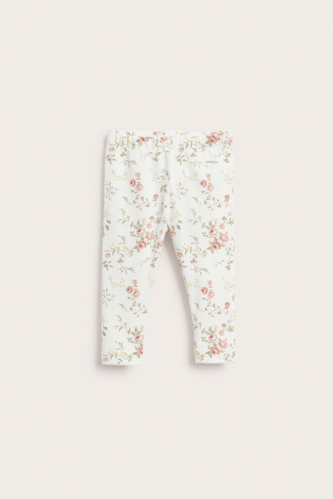 Vorderansicht von cremeweißen Baby-Leggings mit Blumenmuster und Gummizugbund.