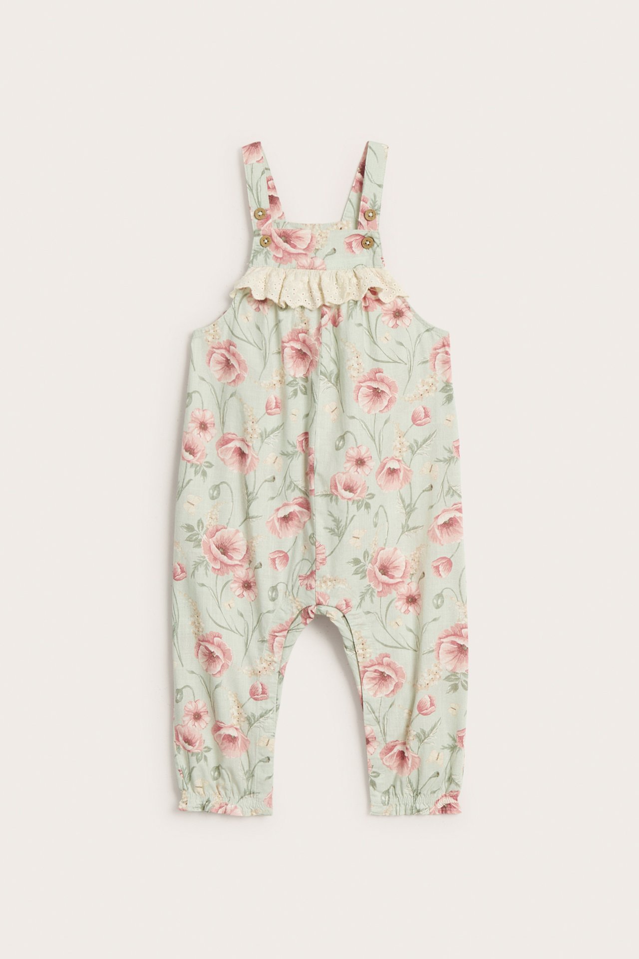 Front view of light green kid's cotton floral dungarees with lace ruffle and buttoned straps.