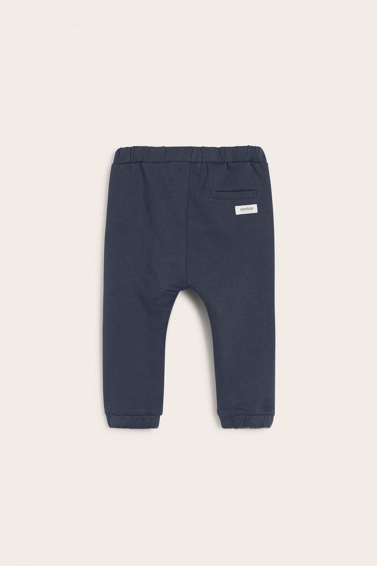 Back view of dark blue baby cotton jogging bottoms with an elasticated waist and ribbed cuffs.