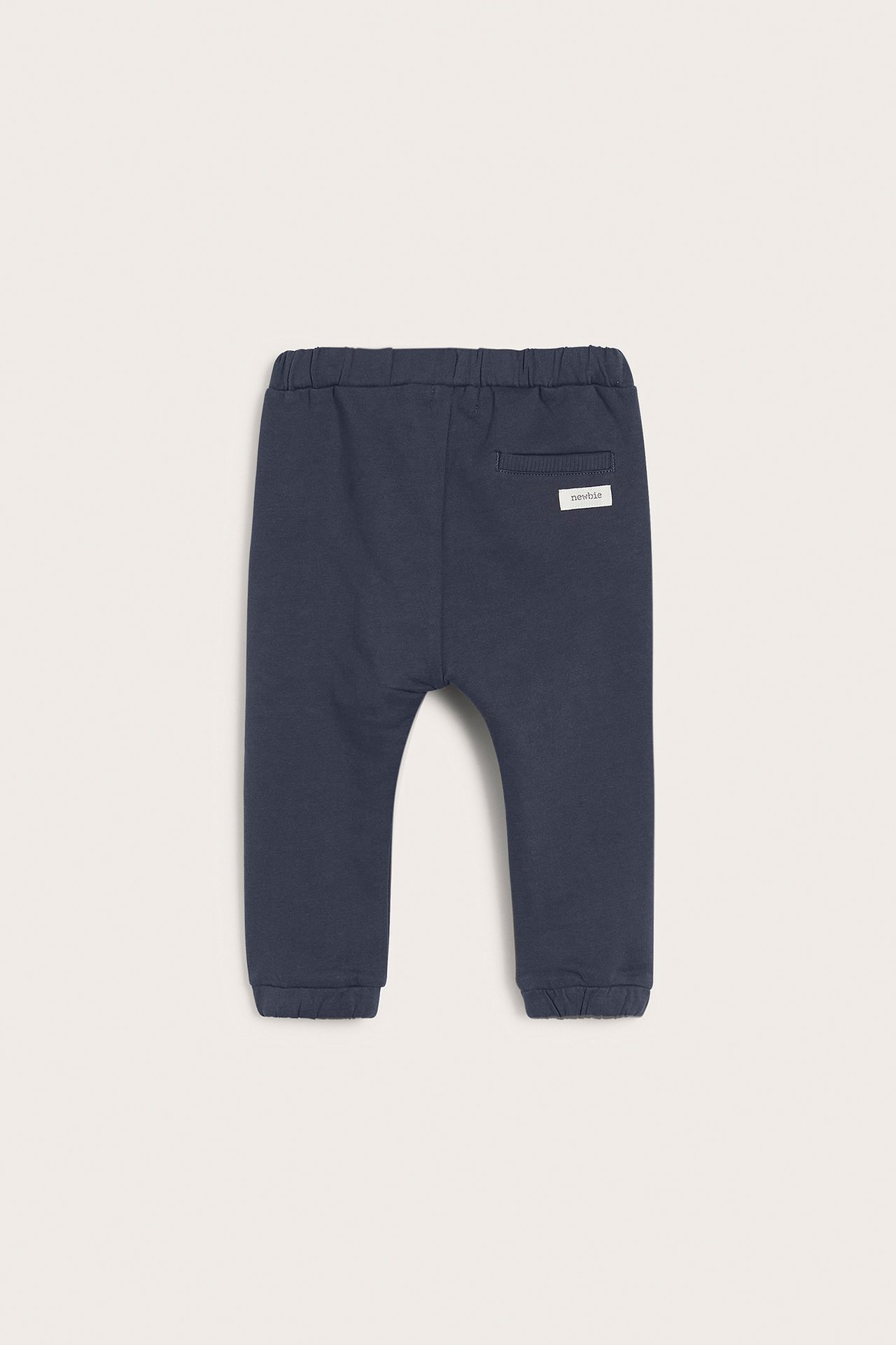 Rückansicht einer dunkelblauen Baby-Jogginghose aus Baumwolle mit Gummizugbund und Rippbündchen.