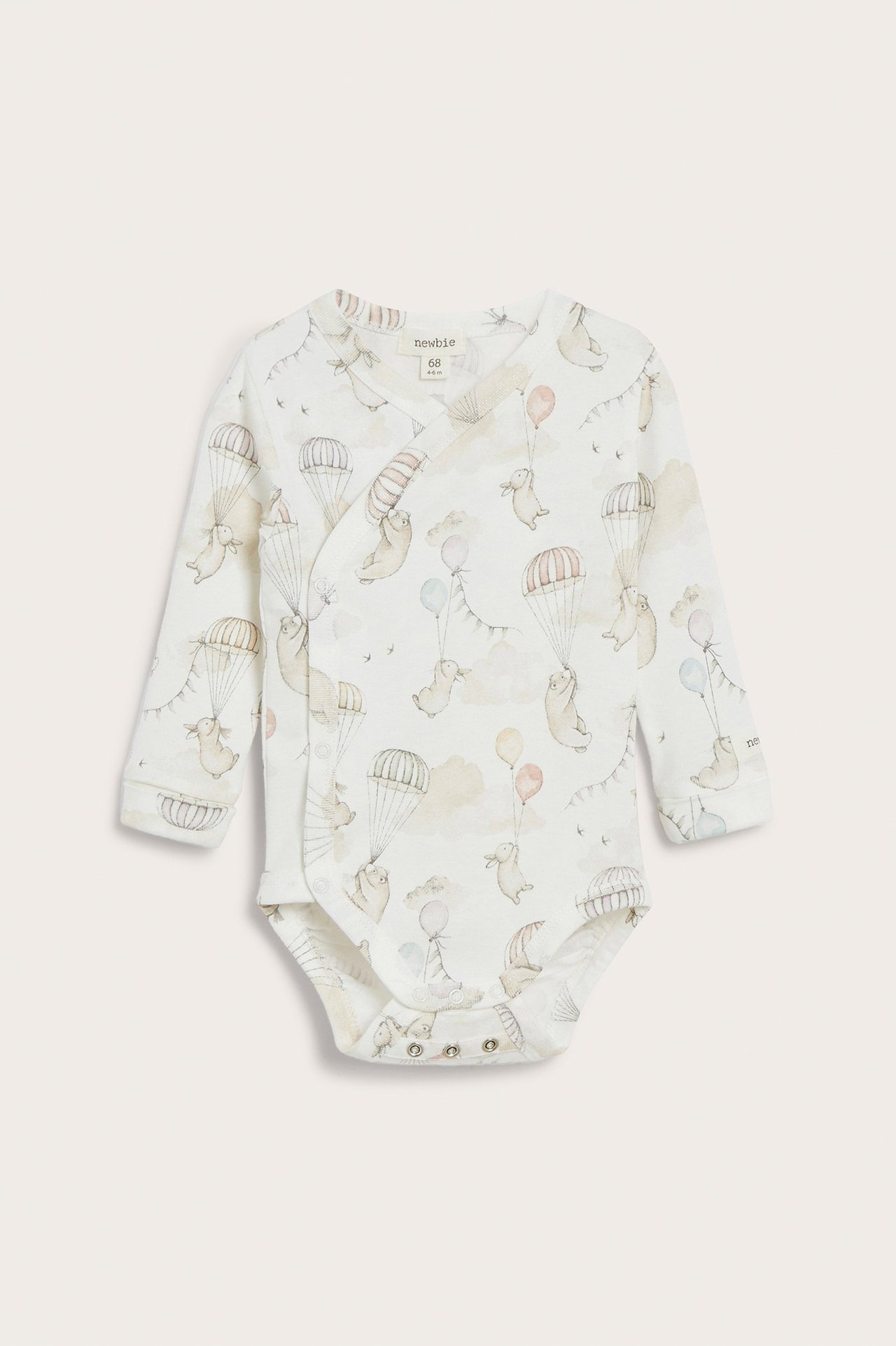 Front view of an off-white cotton baby wrap-around bodysuit with a cute animal and balloon pattern, snap buttons.