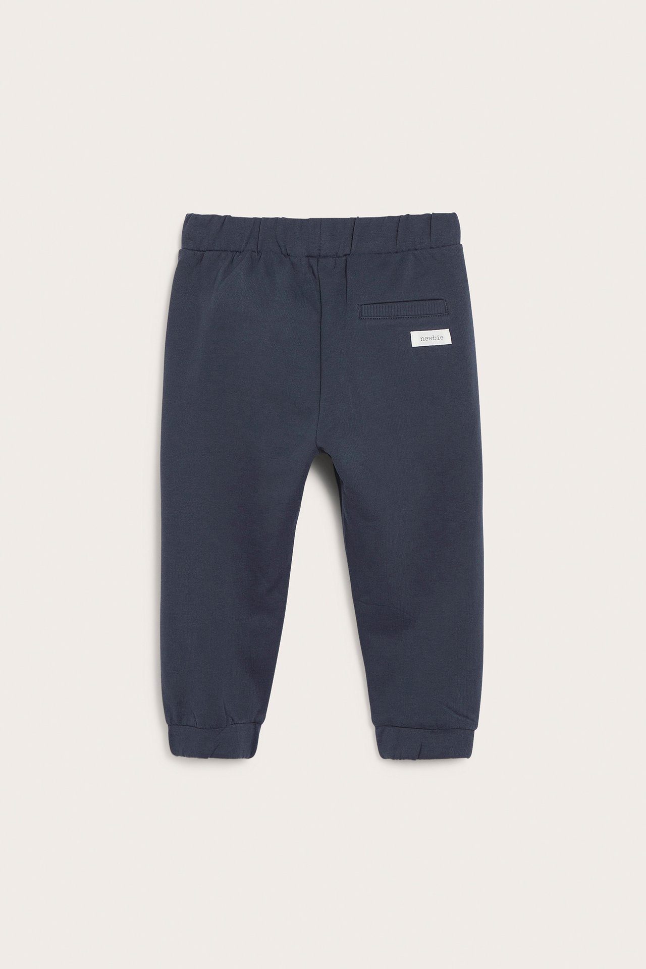 Back view of dark blue baby sweatpants with elasticated waist, ribbed cuffs, and back label.
