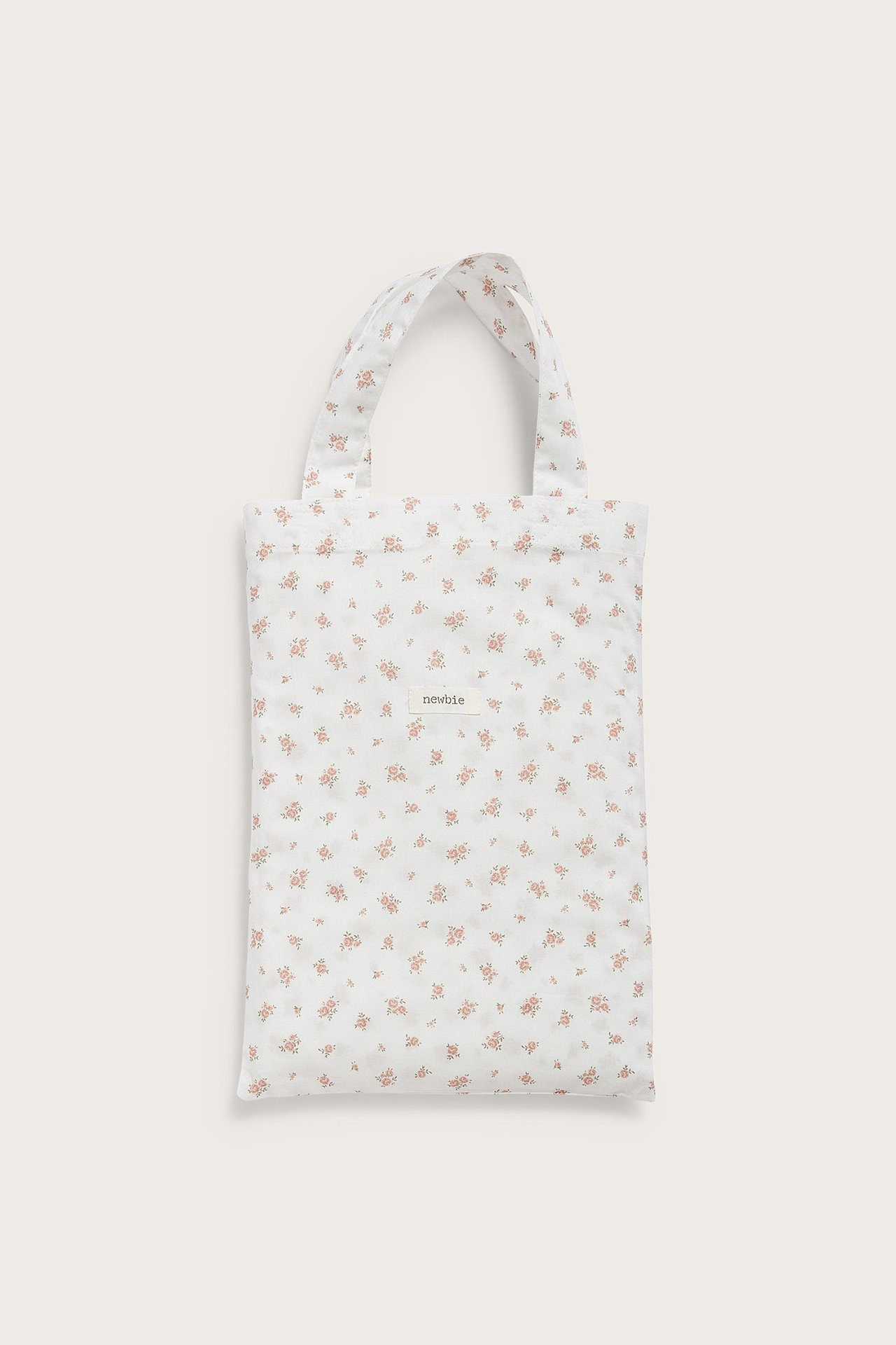 Vorderansicht eines gefalteten cremefarbenen Baumwoll-Bettwäschesets mit kleinem rosa Blumenmuster.