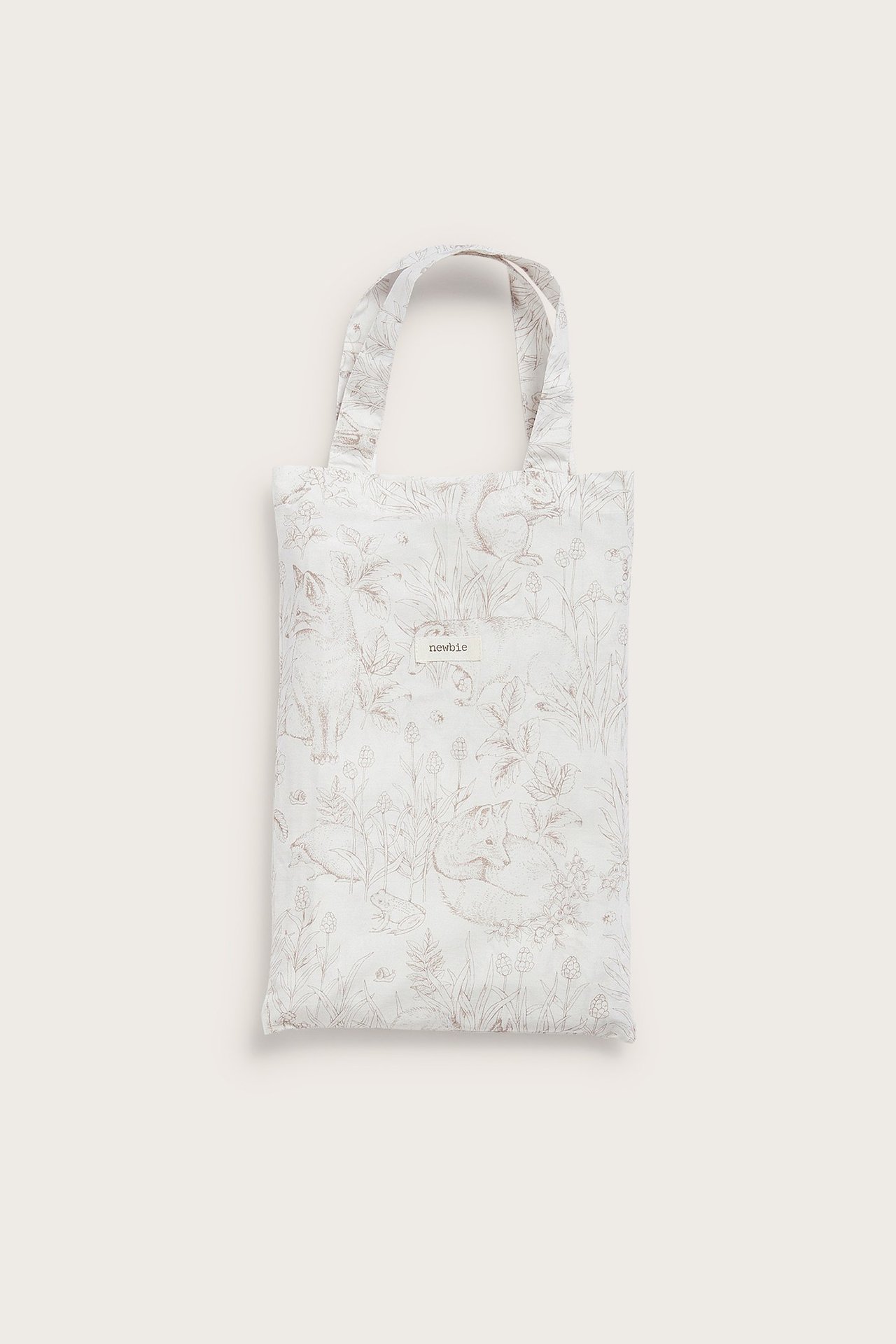 Vorderansicht eines gefalteten cremefarbenen Baumwoll-Bettwäschesets mit braunem Waldmotiv.