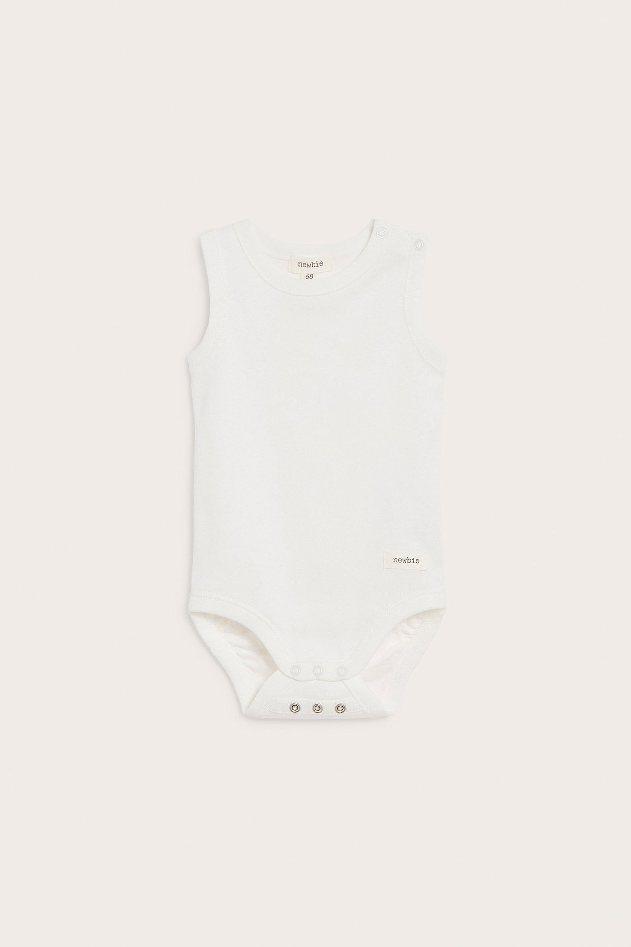 Front view of an off-white sleeveless baby bodysuit made of cotton, with snap buttons at shoulder and crotch.