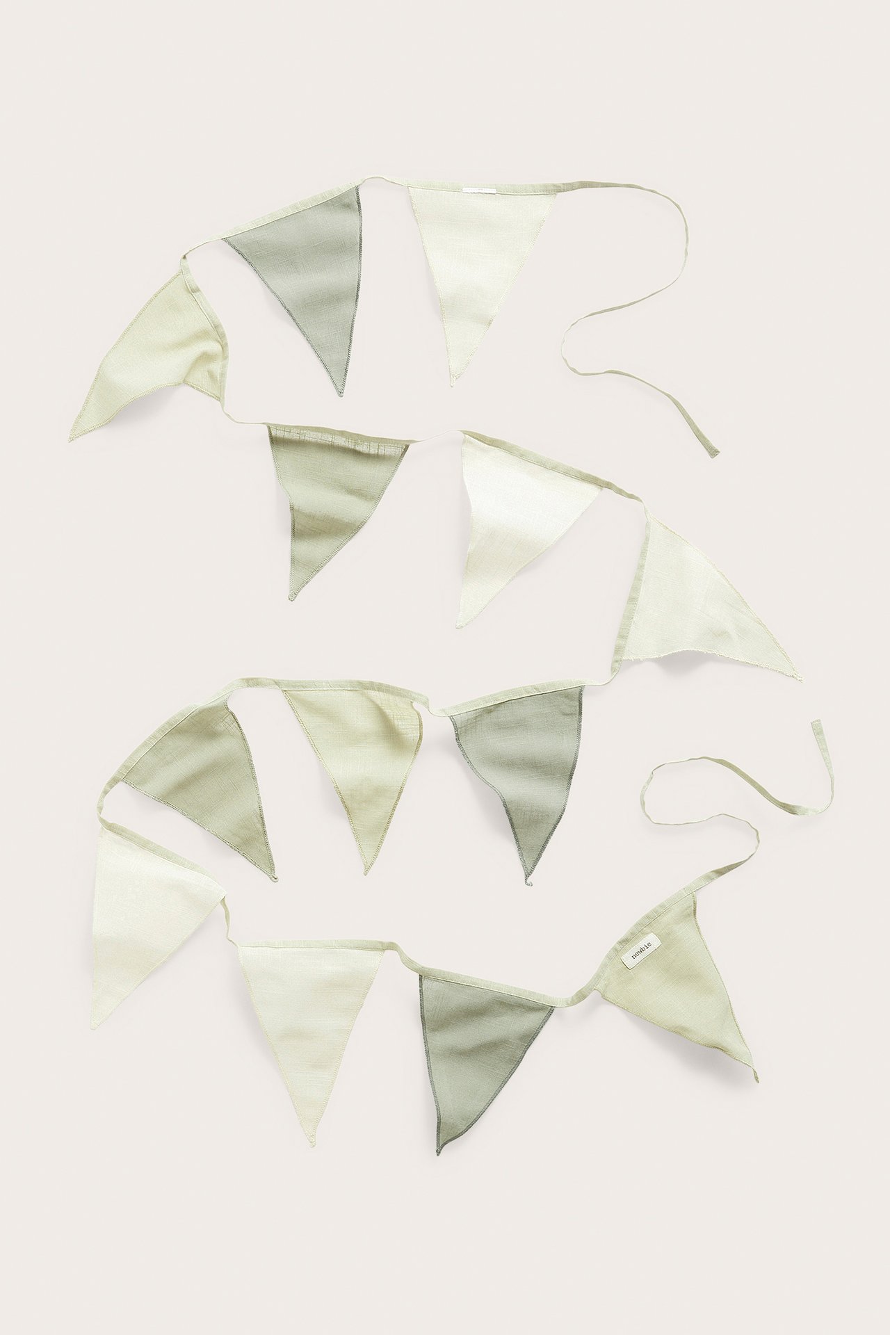 Overhead view: a long bunting with 13 triangular flags, alternating pale green and off-white cotton.