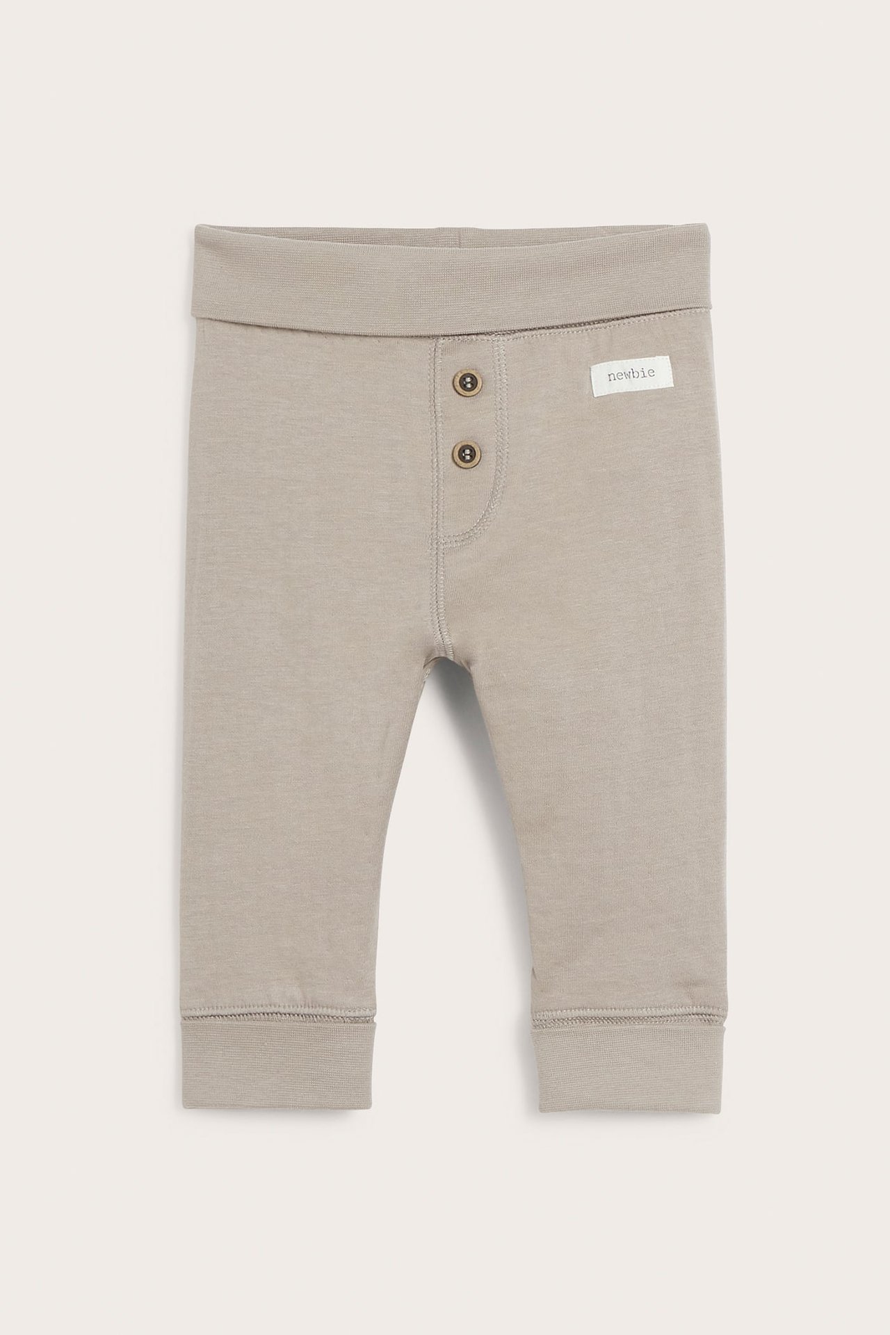 Vorderansicht beige Baby-Leggings mit Umschlagbund, zwei Zierknöpfen und Rippbündchen.