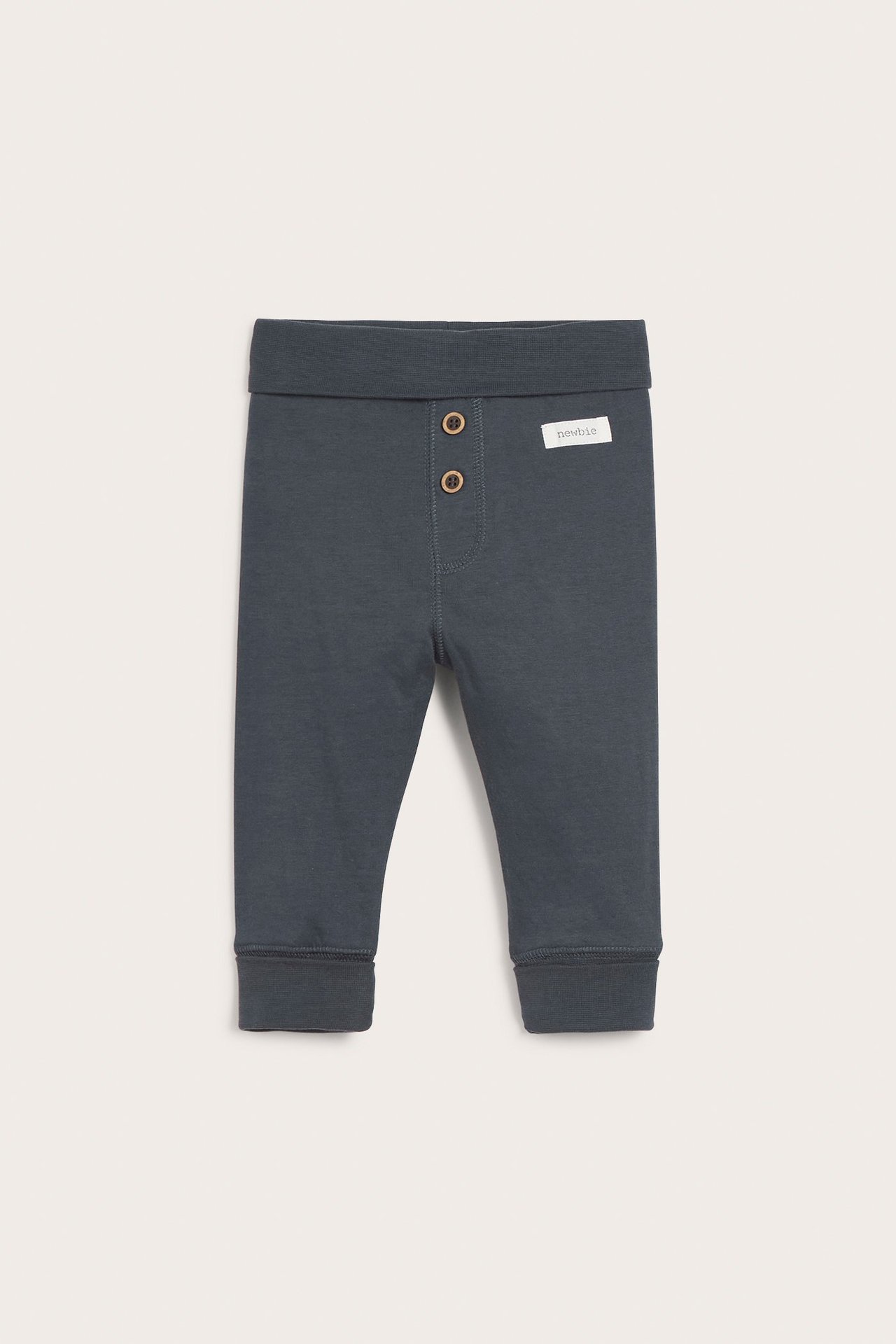 Front view of dark blue baby cotton leggings with a fold-down waist and two decorative wooden buttons.