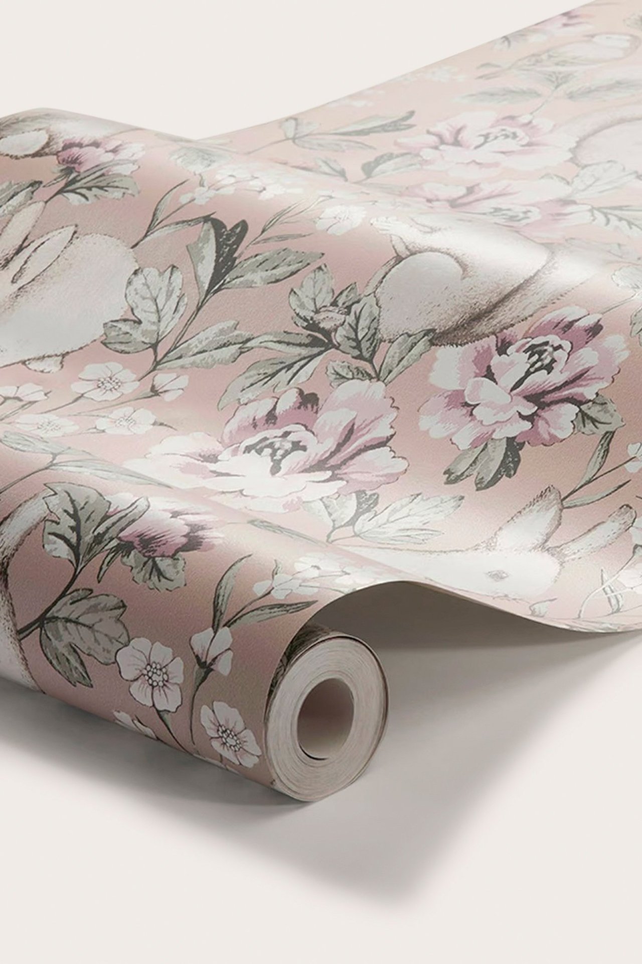 Nahaufnahme einer gerollten rosa Tapete mit einem Muster aus weißen Hasen und rosa Blumen.