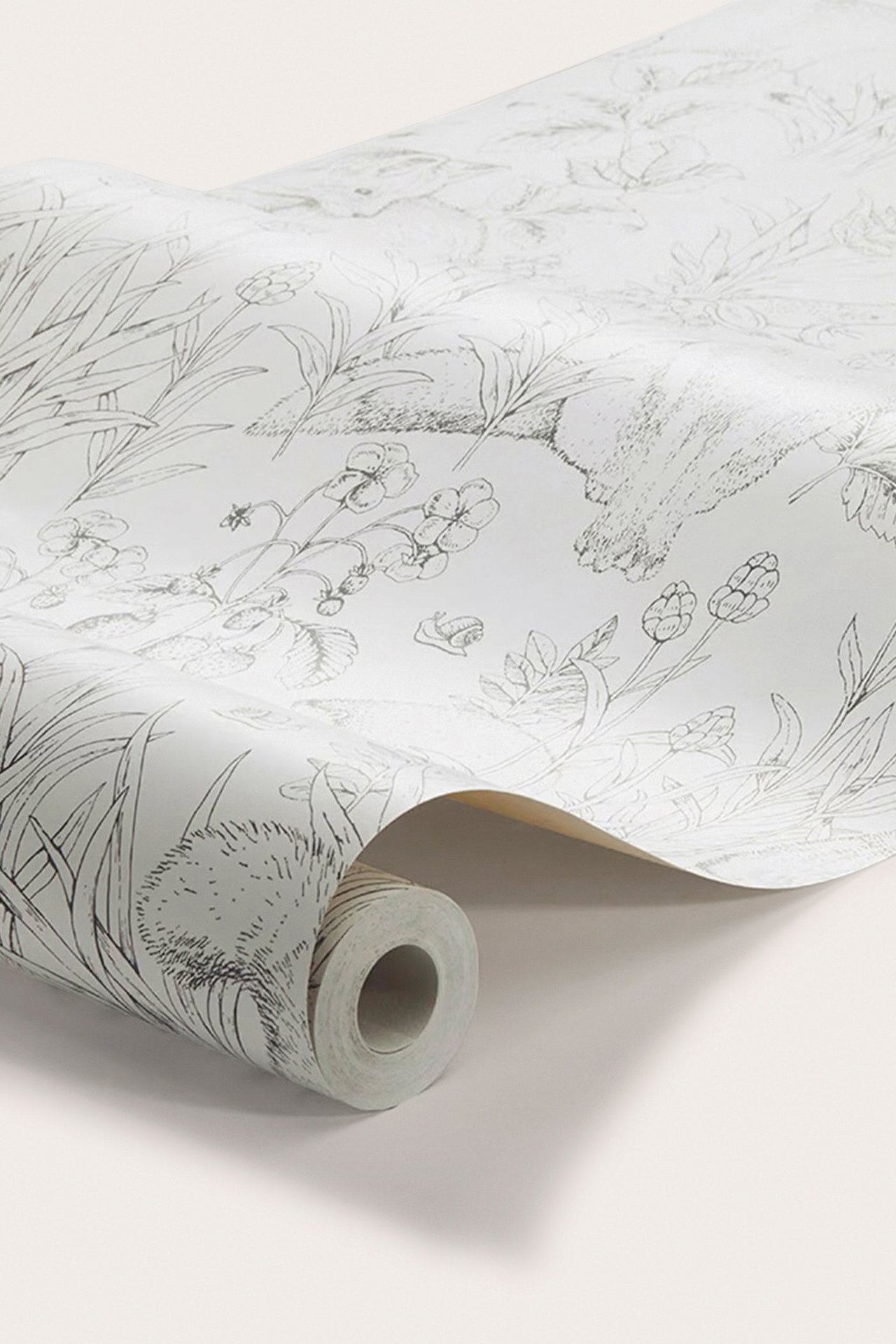 Close-up side view of a white non-woven wallpaper roll with a black forest animal and plant pattern.