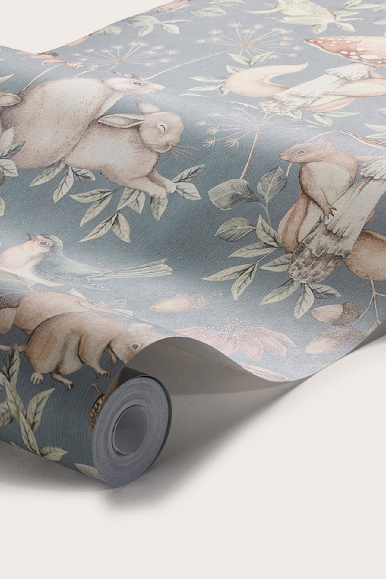 Nahaufnahme einer blauen Tapetenrolle mit sich wiederholendem Muster aus Waldtieren und Pflanzen.
