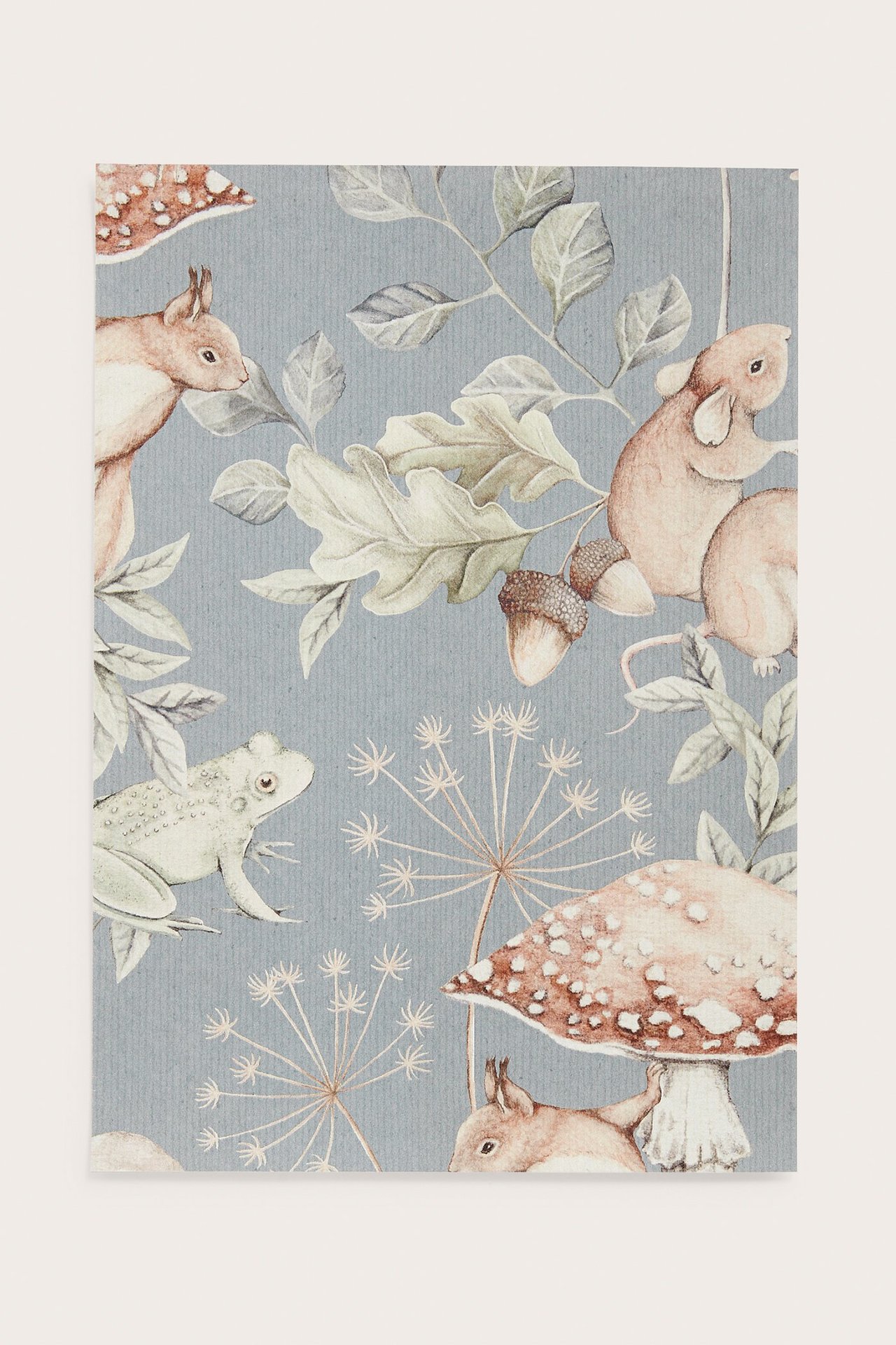 Vorderansicht einer blauen gemusterten Tapetenprobe mit Waldtieren, Blättern, Eicheln und Pilzen.