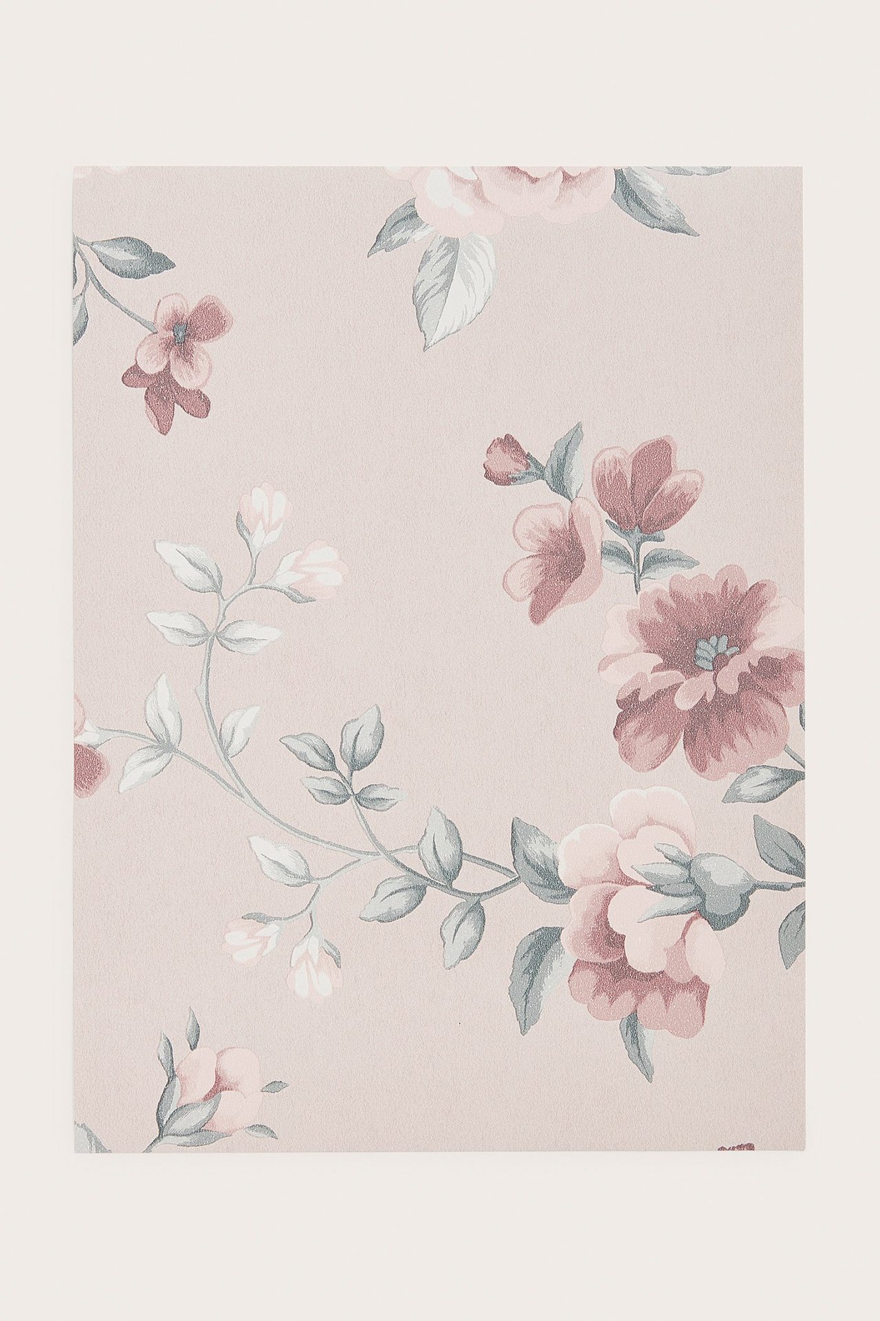 Ganzansicht einer hellrosa Vliestapetenprobe mit Blumenmuster.
