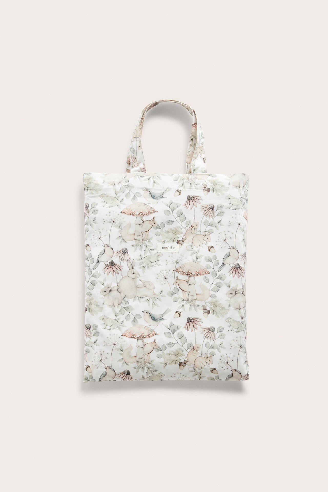 Front view of a light beige cotton tote bag with a detailed forest and animal print.