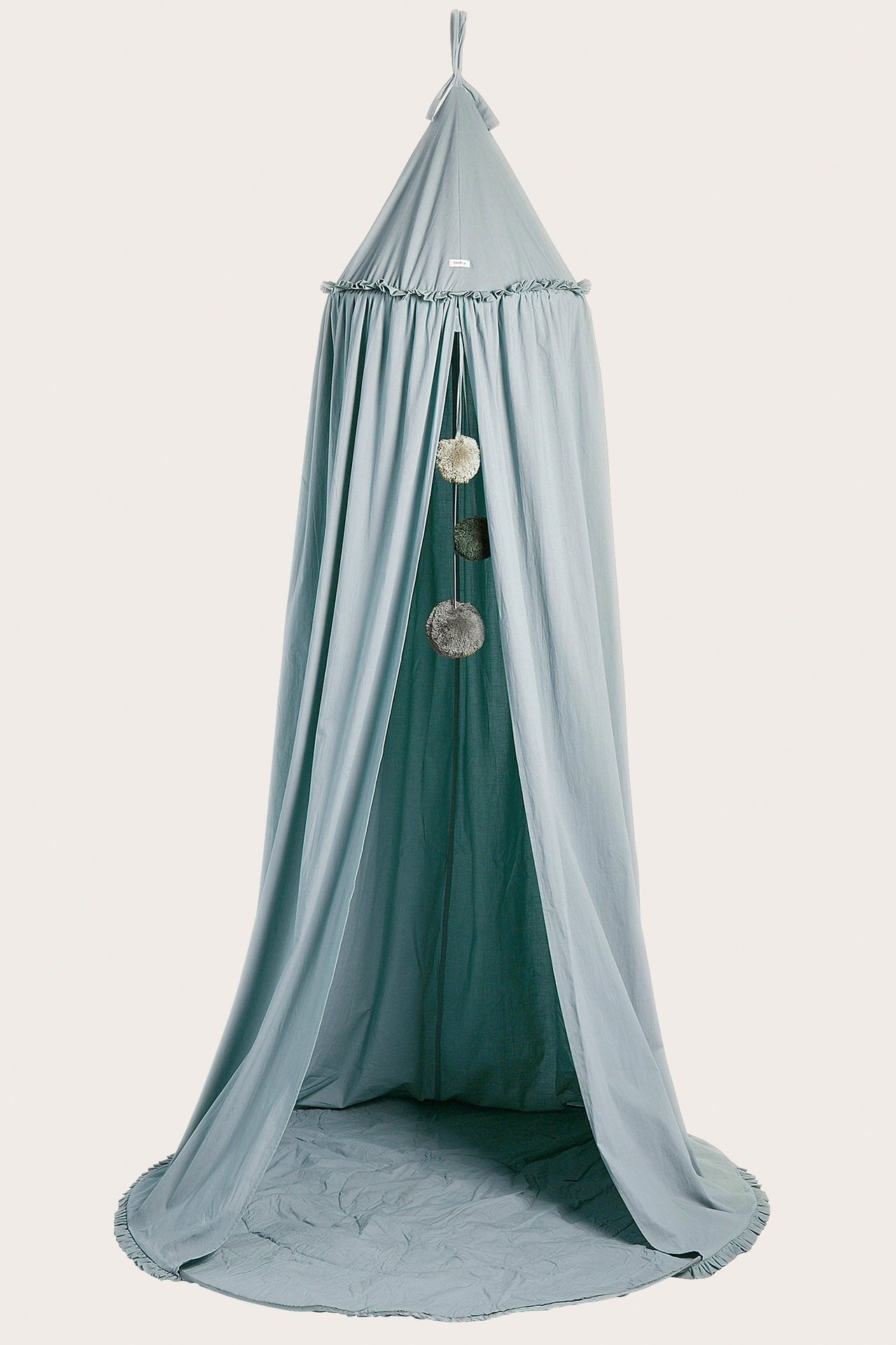 Vorderansicht eines hellblauen Leselagers mit gepolstertem Boden und hängenden dekorativen Pompons.