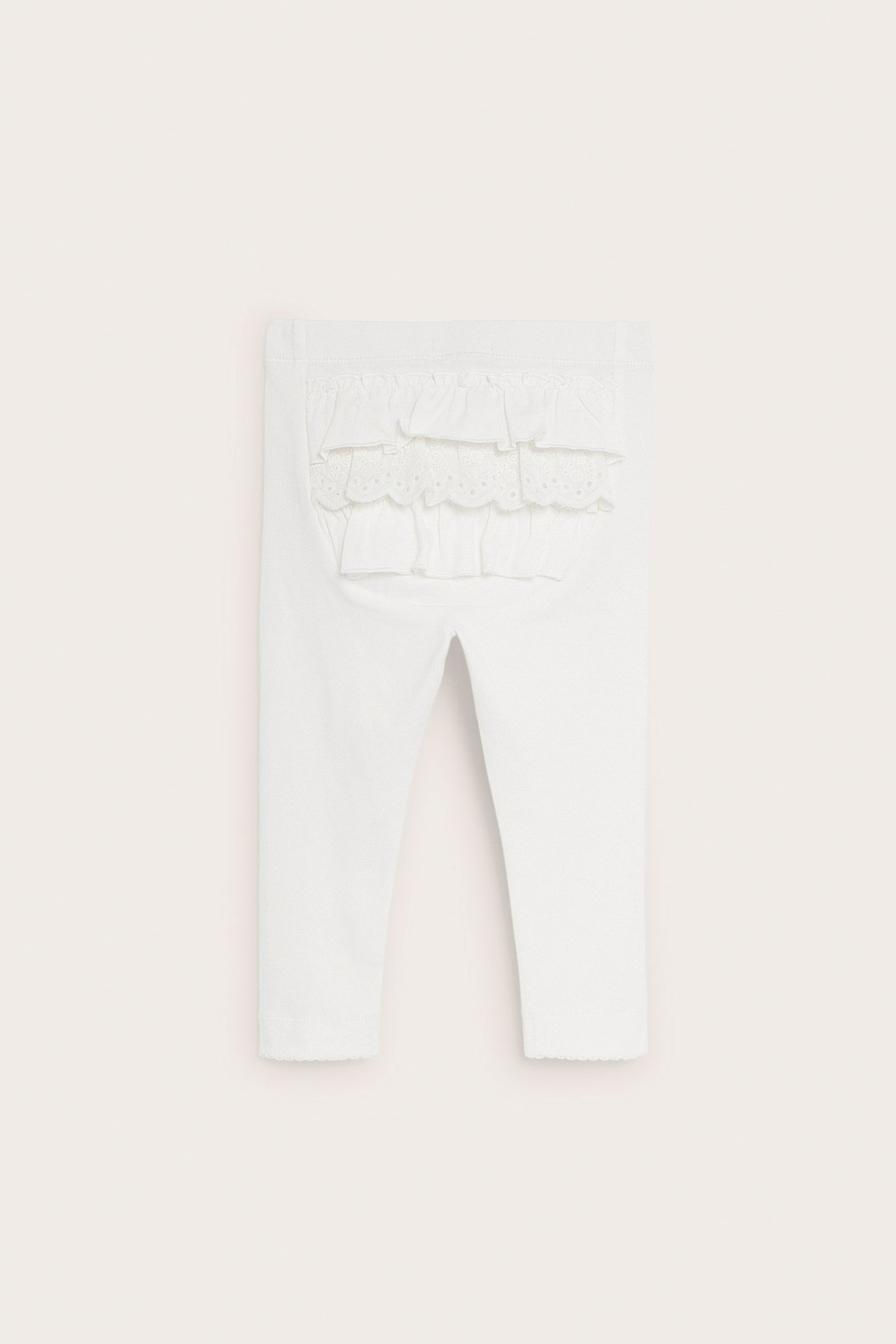Back view: off-white baby leggings with frills and lace on the back, elastic waist, picot hem.