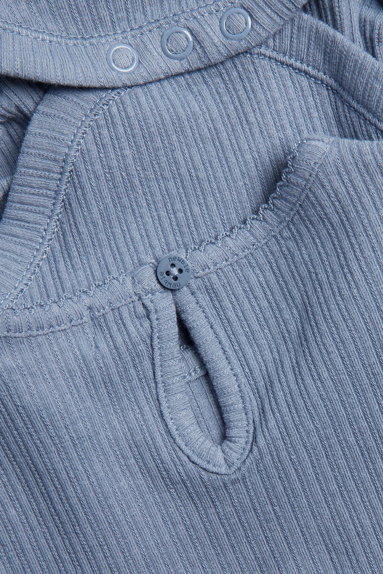 Nahaufnahme eines blauen gerippten Babybodys mit Knopfverschluss hinten und Druckknöpfen an der Schulter.