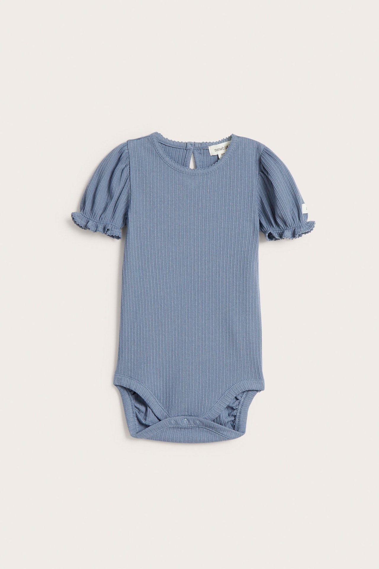 Vorderansicht eines einfarbigen blauen gerippten Jersey-Babybodys mit kurzen Puffärmeln, Picot-Rand und Druckknöpfen.
