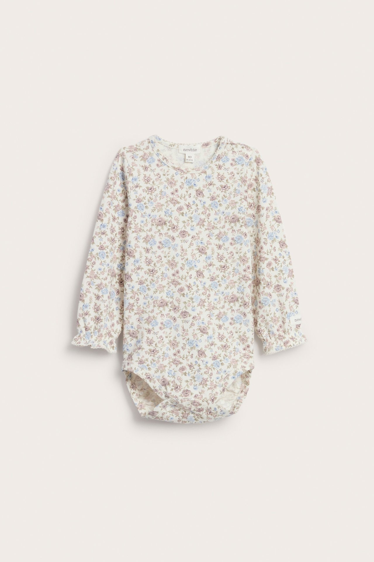 Front view of an off-white long-sleeved baby body with a floral pattern and ruffled cuffs.
